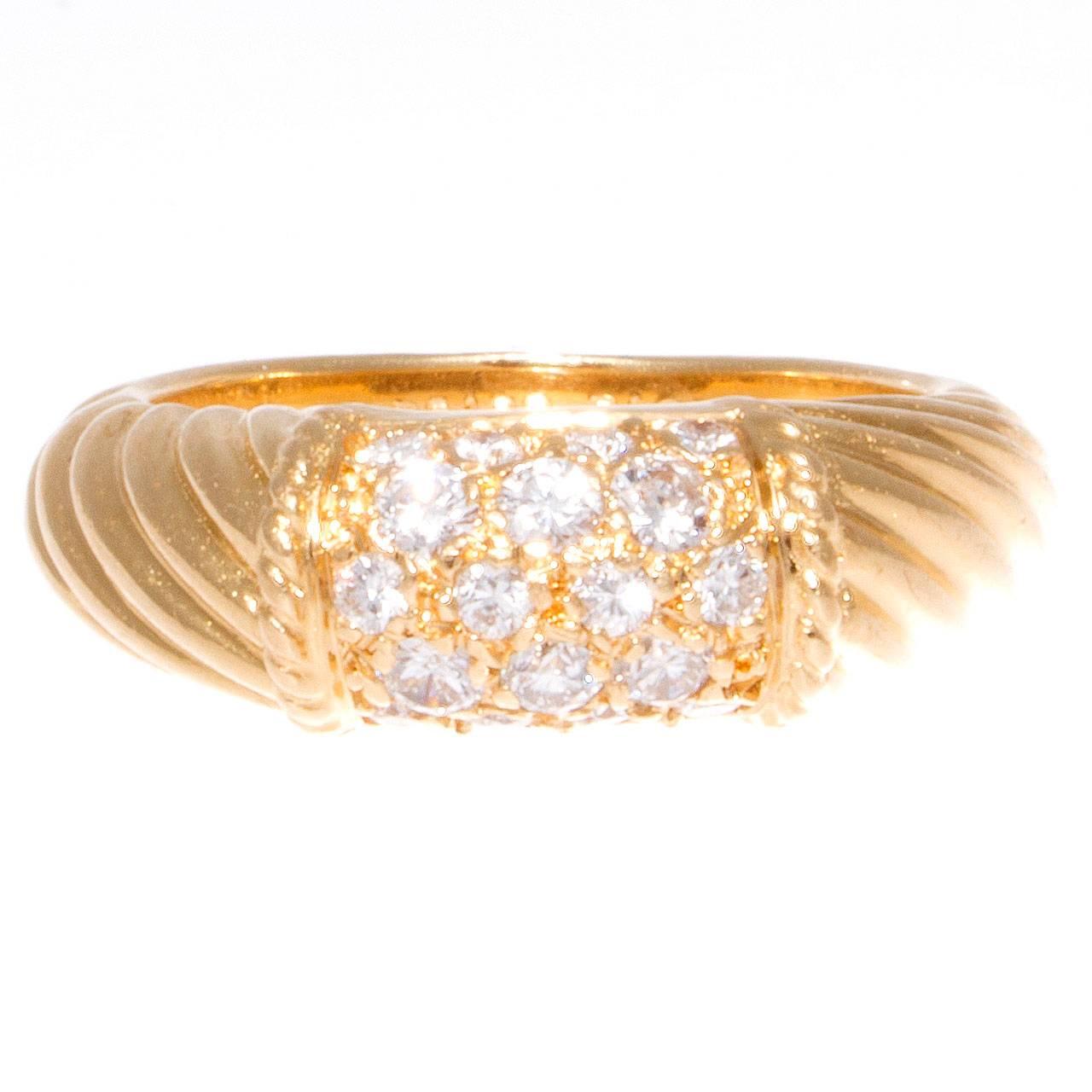 Elegance and timeless fashion from the French designers at Van Cleef & Arpels. This ring features numerous near colorless diamonds pave set in the twisting 18k yellow gold. Signed VCA and numbered.

Ring size 6 1/4 and may be re-sized.