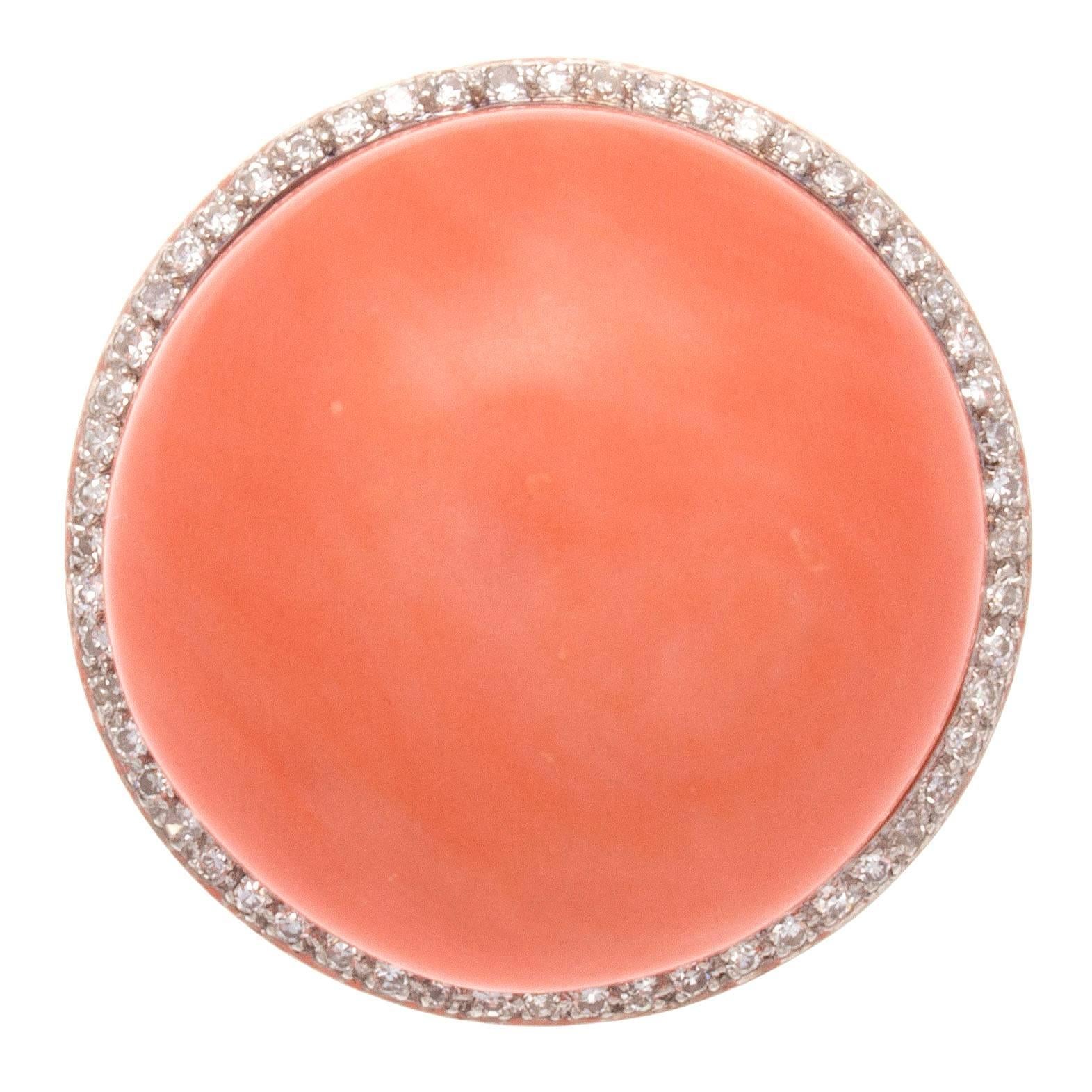 A retro creation that is true to its larger than life time period. Designed with substantial large orangish-red cabochon cut coral and surrounded by a halo of clean, white diamonds. Hand crafted in an intricate 14k white gold design.

Diameter 1