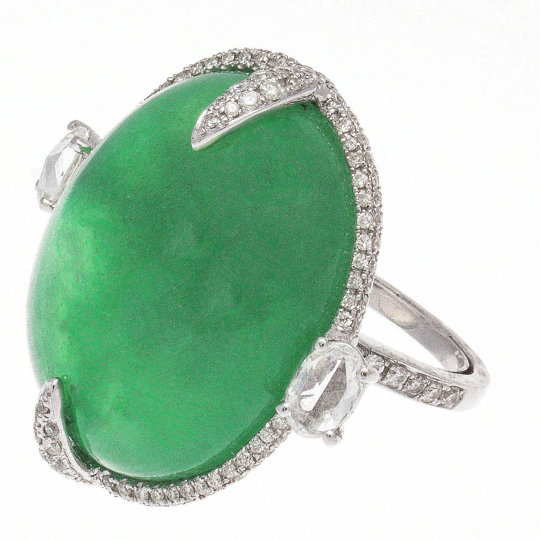 Big bold creative design, featuring a large cabochon translucent and vibrant green quartz surrounded by a halo of clean, white diamonds. Hand crafted in platinum.

Ring size 5-3/4 and may be re-sized.