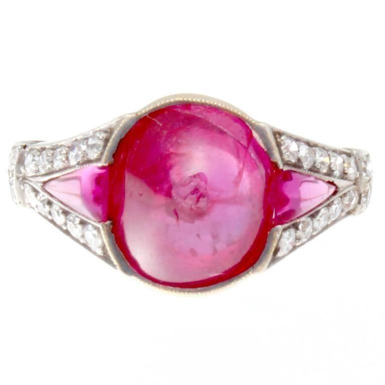 A natural approximately 5 carat ruby has been GIA certified as Burmese origin with no indications of heat treatment or any other type of enhancements. The cabochon cut ruby is a vivid purplish red color and has been accented by two perfectly