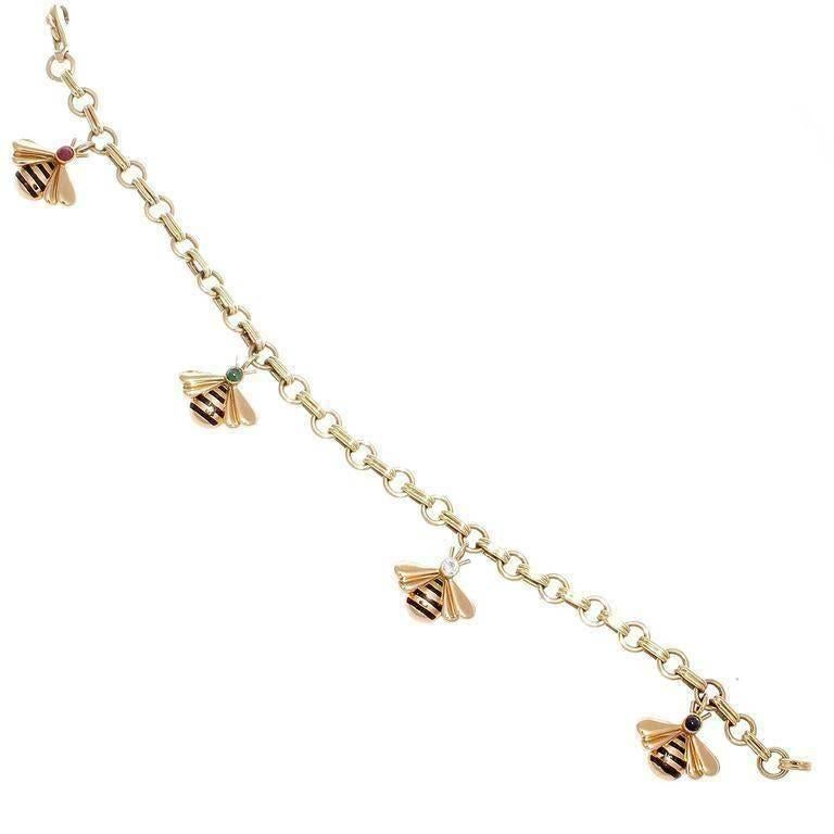 Ein modernes Design von Cartier. Mit vier flatternden Hummel-Anhängern:: die mit Streifen aus Emaille und Köpfen aus Diamanten:: Smaragden:: Rubinen und Saphiren gestaltet sind. Gefertigt aus 18 Karat Gelbgold. Signiert Cartier:: nummeriert und