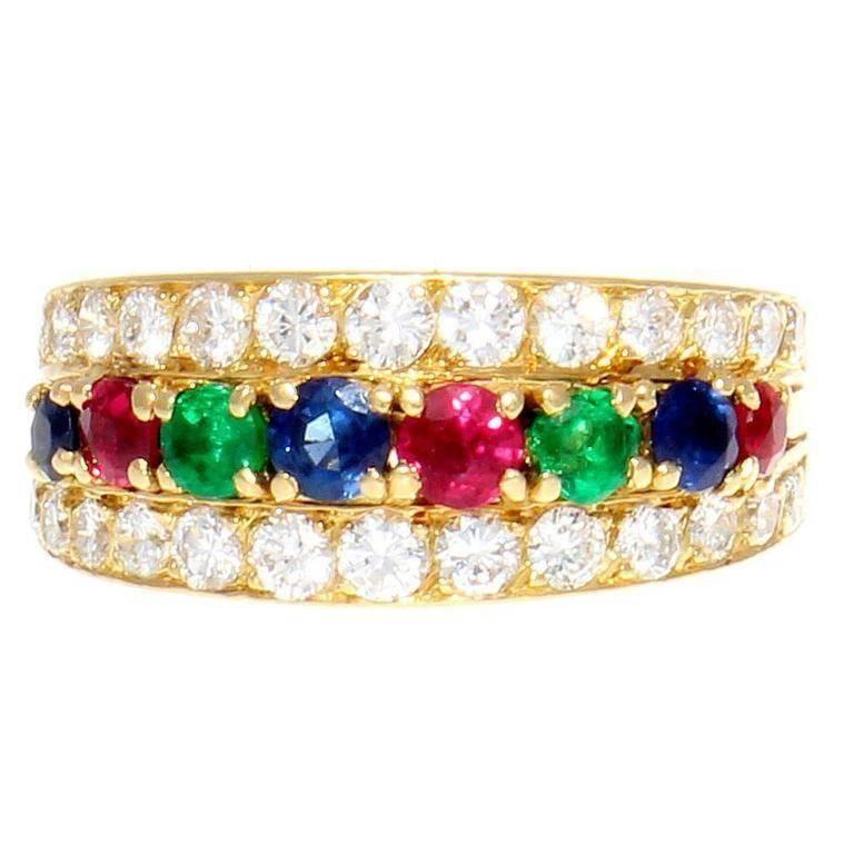 A lively presentation featuring a prism of color by Van Cleef and Arpels. This colorful creation is designed with an array of superior rubies, sapphires and emeralds and are embraced by flowing rows of white, clean round cut diamonds. Signed VCA,