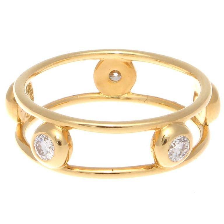 An intelligent design capturing 5 freely orbiting clean, white diamonds between two perfectly round lines of vibrant yellow 18k gold. Signed T & Co. Peretti. 

Ring size 5.