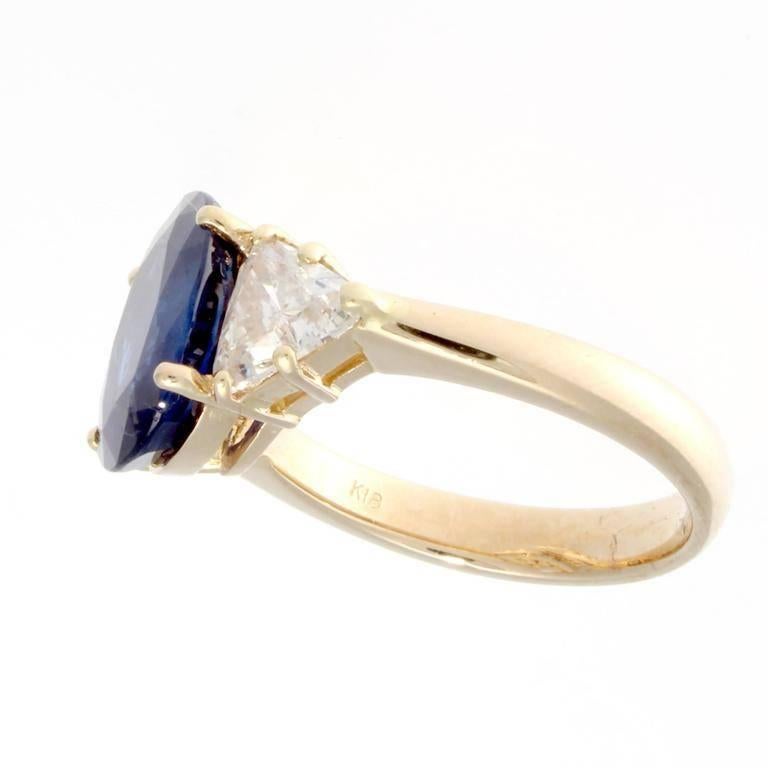 A natural 4.22 carat sapphire that has been GIA certified as heat treated with origin not requested. The vibrant deep blue oval cut sapphire has been complimented perfectly by two nearly colorless trillion cut diamonds that weigh 1.26 carats total.
