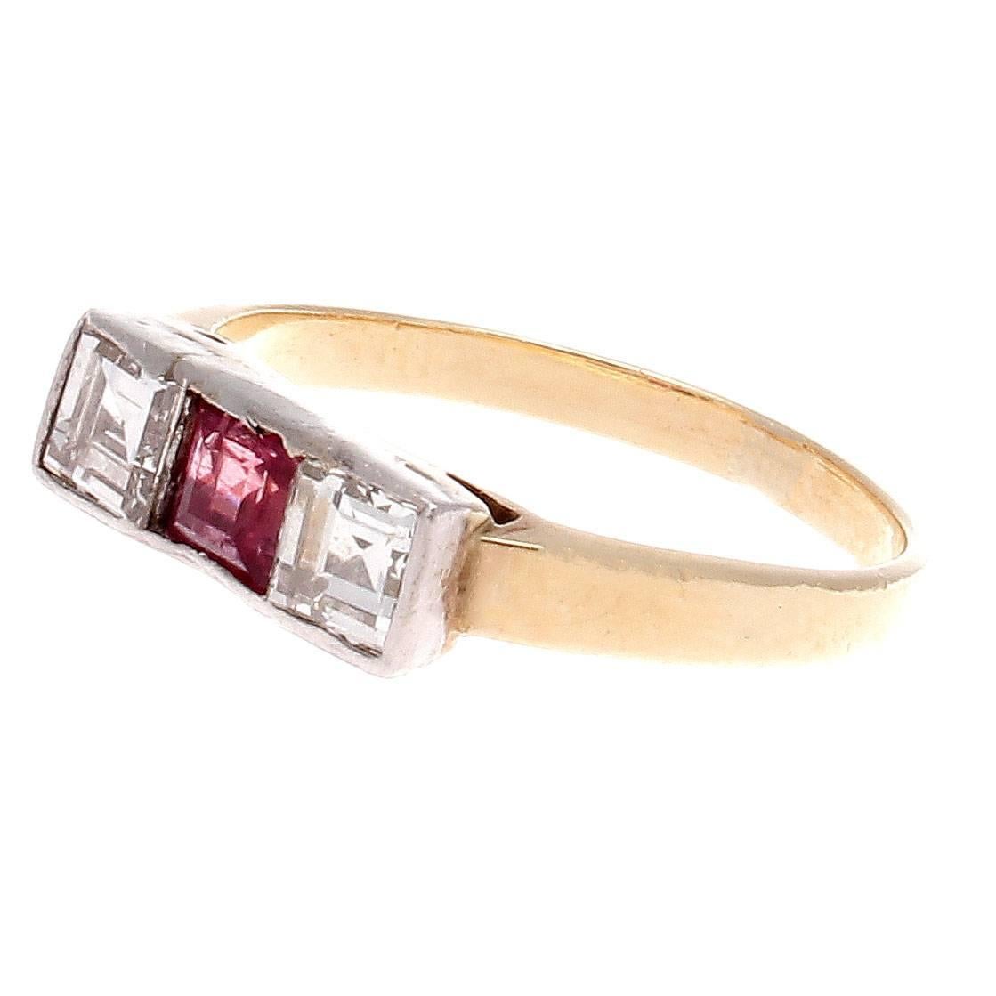 Dazzling refinement in the classic art deco symmetrical design. Featuring a vibrant asscher cut reddish-pink ruby accented on either side by an asscher cut white, clean diamond. Hand crafted in platinum and 18k yellow gold.

Ring size 4-1/2 and may