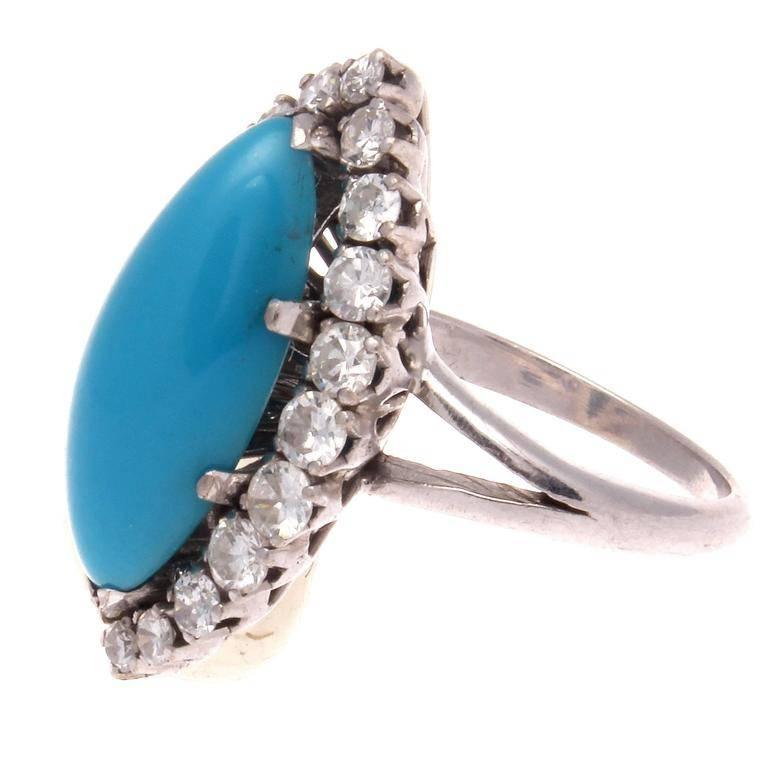 An eye catching iconic cluster design of clean, colorful elegance. Featuring an unusual bright blue marquise cut turquoise perfectly surrounded by a halo of numerous near colorless diamonds. Crafted in platinum.

Ring size 6-1/2 and may be resized.