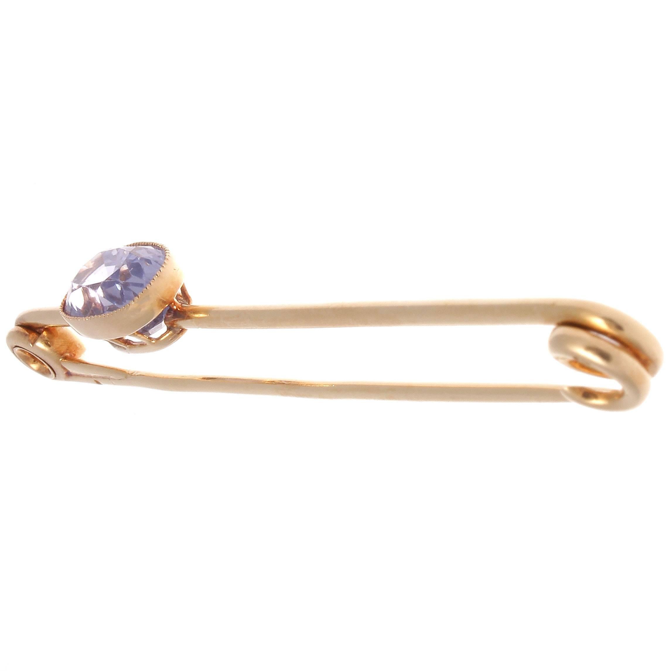 The French sophistication and creativity is unmatched in design. This creative safety-pin exemplifies the bold larger than life designs of the Retro period. 

Featuring an approximately 7.80 carat rich purplish/violet oval cut sapphire that is