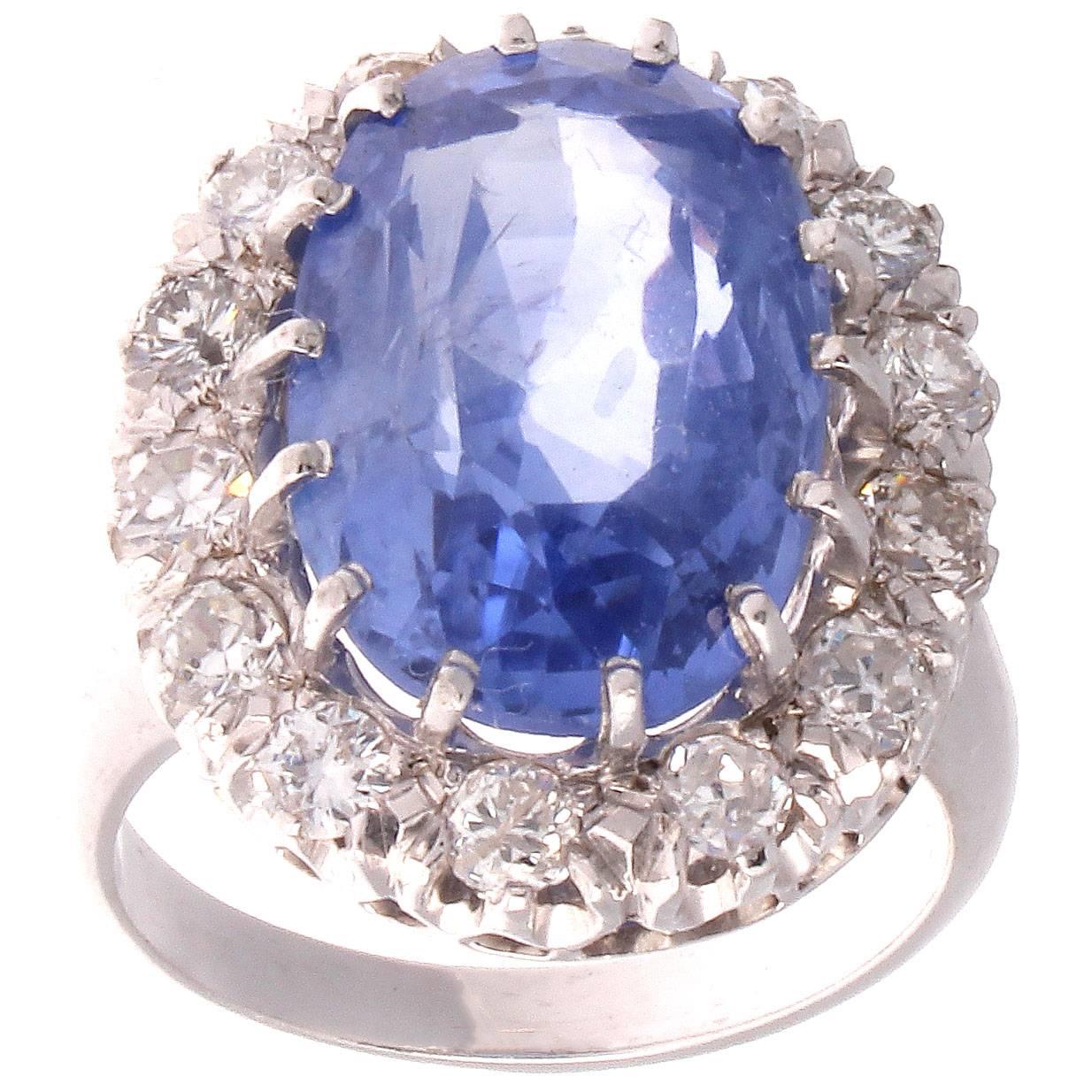 The classic Sapphire engagement ring. Featuring a 12.55 carat cornflower blue sapphire that is accompanied with a Guild Laboratories certificate stating it is of Ceylon origin with no indications of heat or other treatment. Surrounded by a halo of