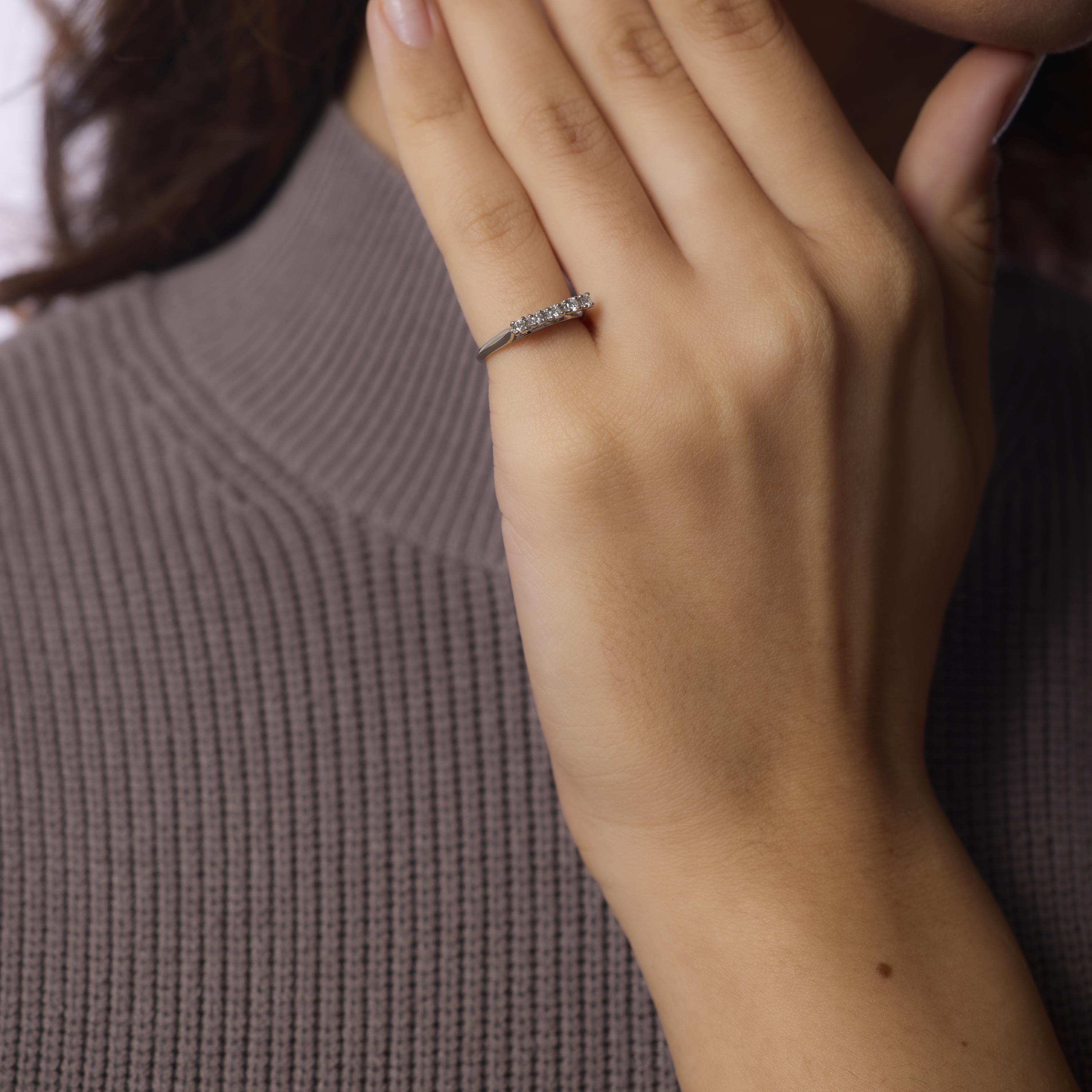 Cette bague d'éternité en or blanc 18 carats du milieu du siècle présente cinq diamants ronds de taille brillante dans un anneau minimaliste et élégant. Fabriqué dans les années 1960, son éclat vif et son profil élégant en font une pièce