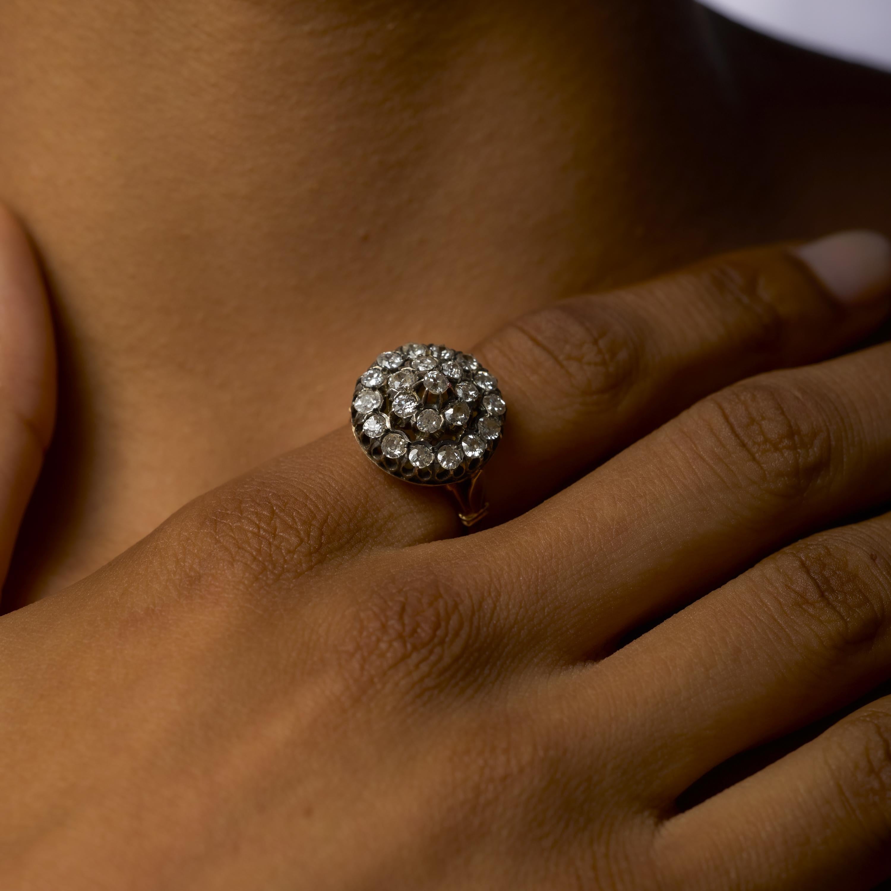 Questo eccezionale anello edoardiano del 1910 presenta al centro un diamante taglio old mine di circa 0,85 carati, che risplende di calore e brillantezza vintage. Intorno ad esso ci sono ventitré diamanti europei e di vecchio taglio per un totale di