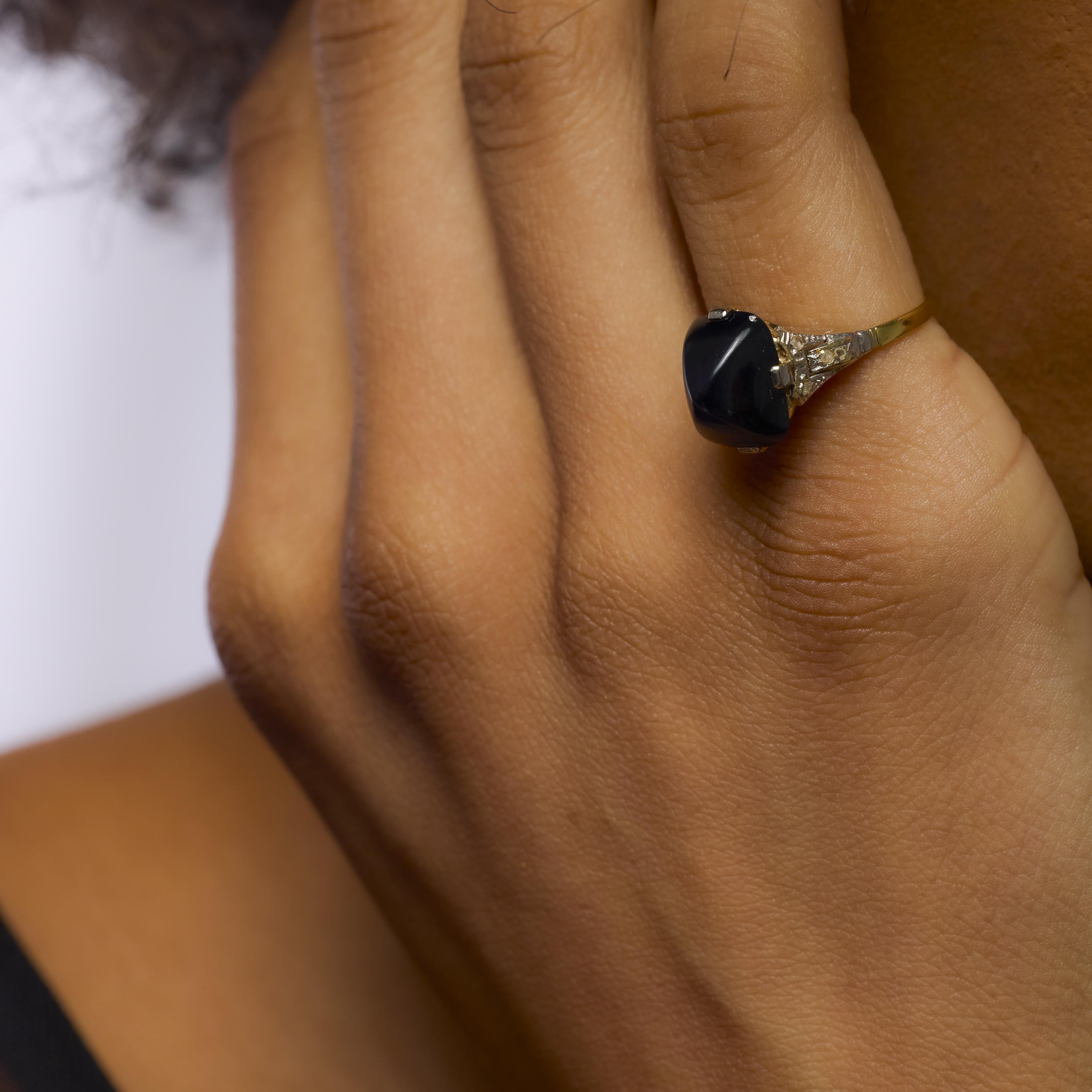Cette captivante bague Art déco des années 1930 est centrée sur un saphir bleu foncé de 6,99 carats taillé en pain de sucre, dont la surface bombée et le ton profond lui confèrent un air de mysticisme et de raffinement. Huit diamants taillés en