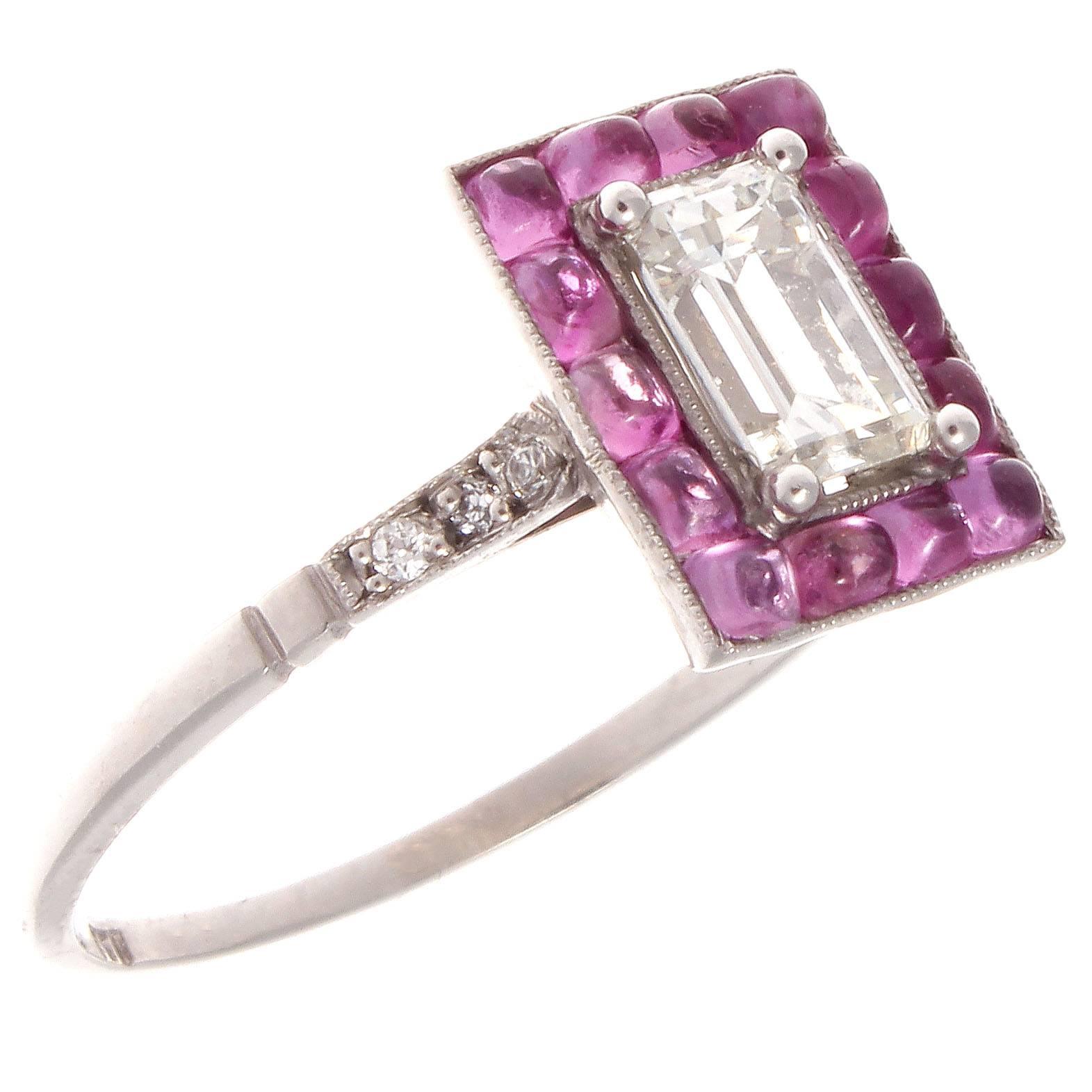 A modern rendition of the classic halo ring. Featuring a 0.71 carat emerald cut diamond that is surrounded by a halo of cabochon cut pink sapphires. Crafted in platinum.

Ring size 7 and may be resized. 