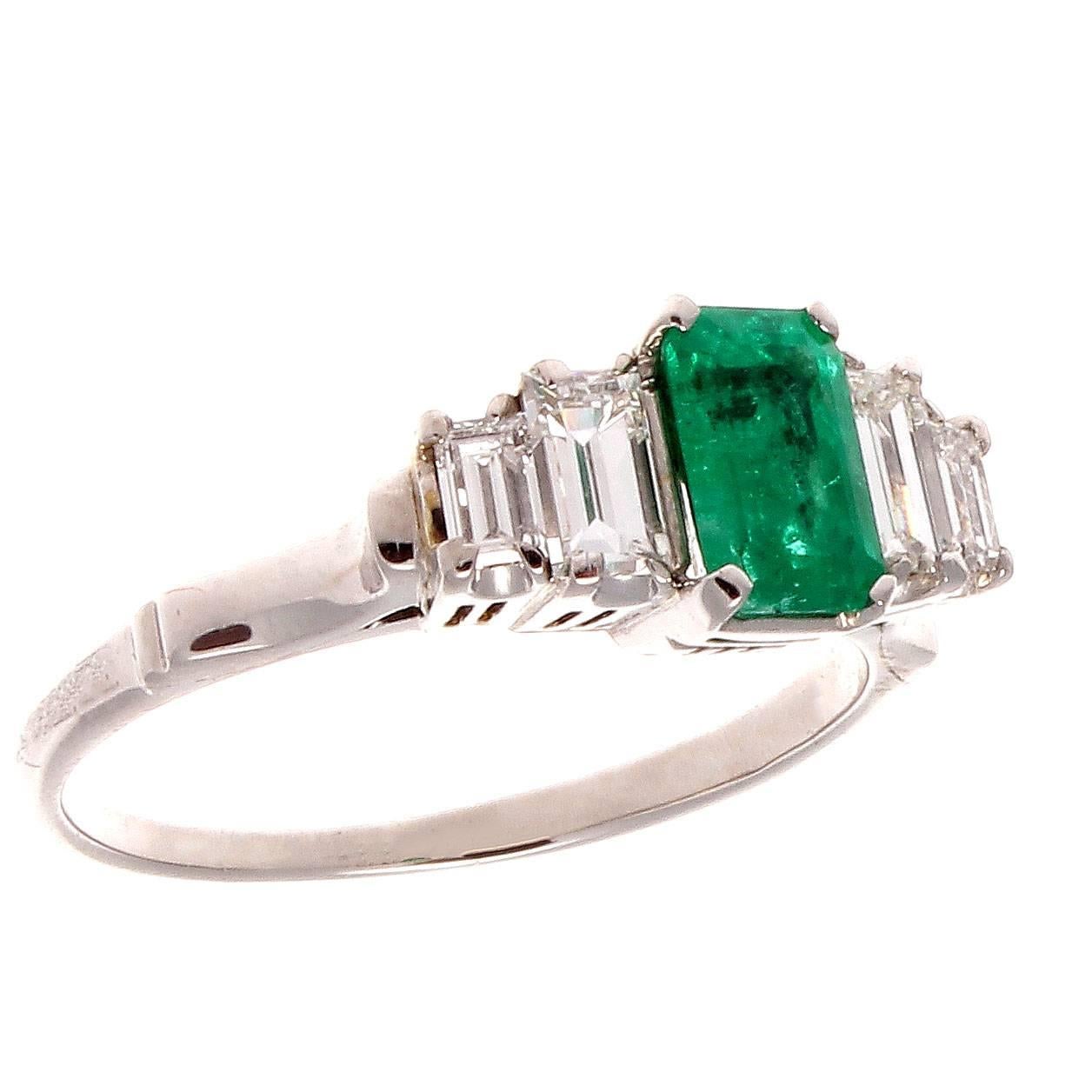 Color is the focus of this modern engagement ring. Featuring a 0.70 carat Colombian forest green emerald accented by emerald cut diamonds weighing approximately 0.50 carats that are F color, VS1 clarity. Crafted in platinum.

Ring size 6 and may be