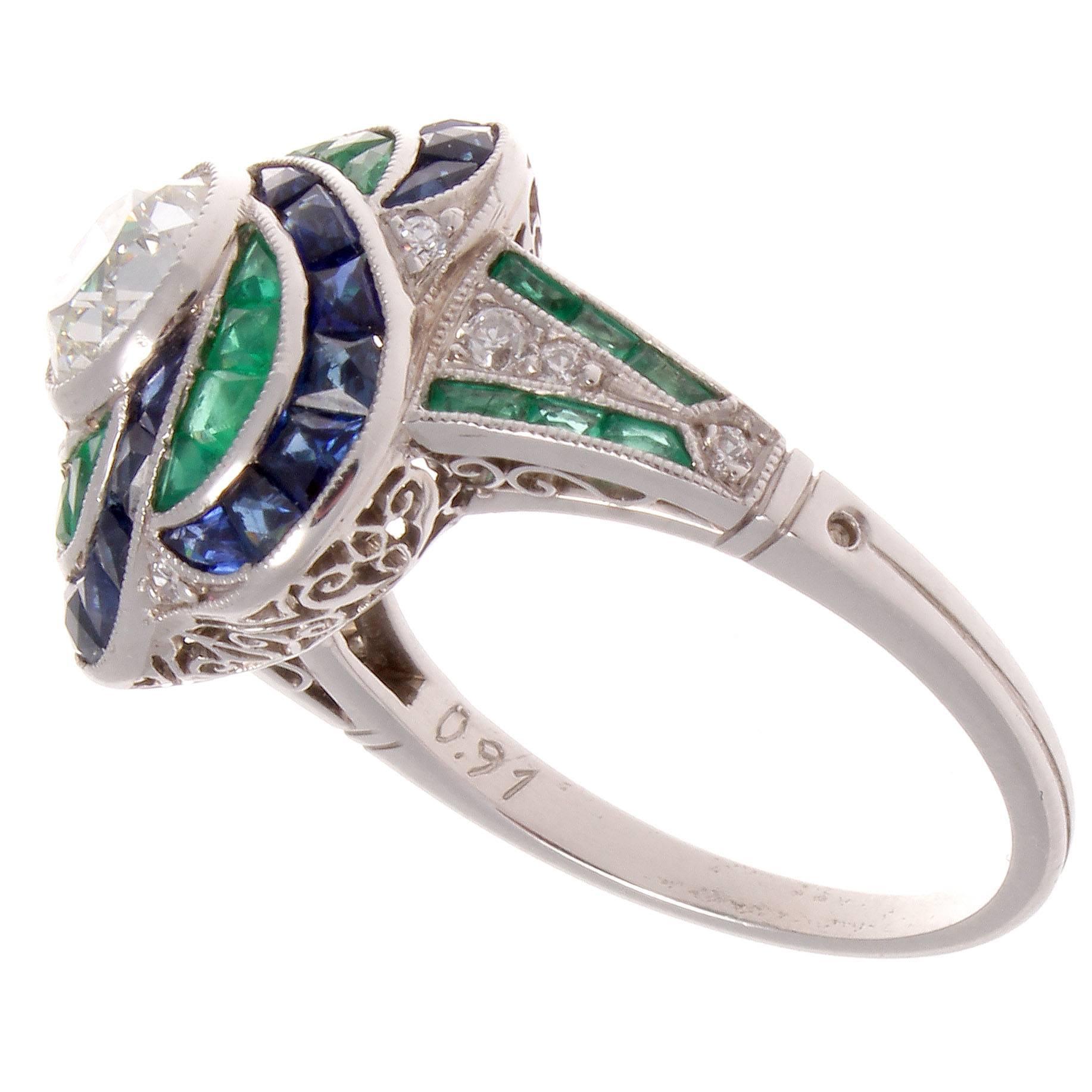 A swirl of emeralds and sapphires surround the 0.91 old European cut diamond. The diamond is I color and VS clarity. The sapphires and emeralds are specially made calibrated French cut.

Ring size 6 and may easily be re-sized to fit.