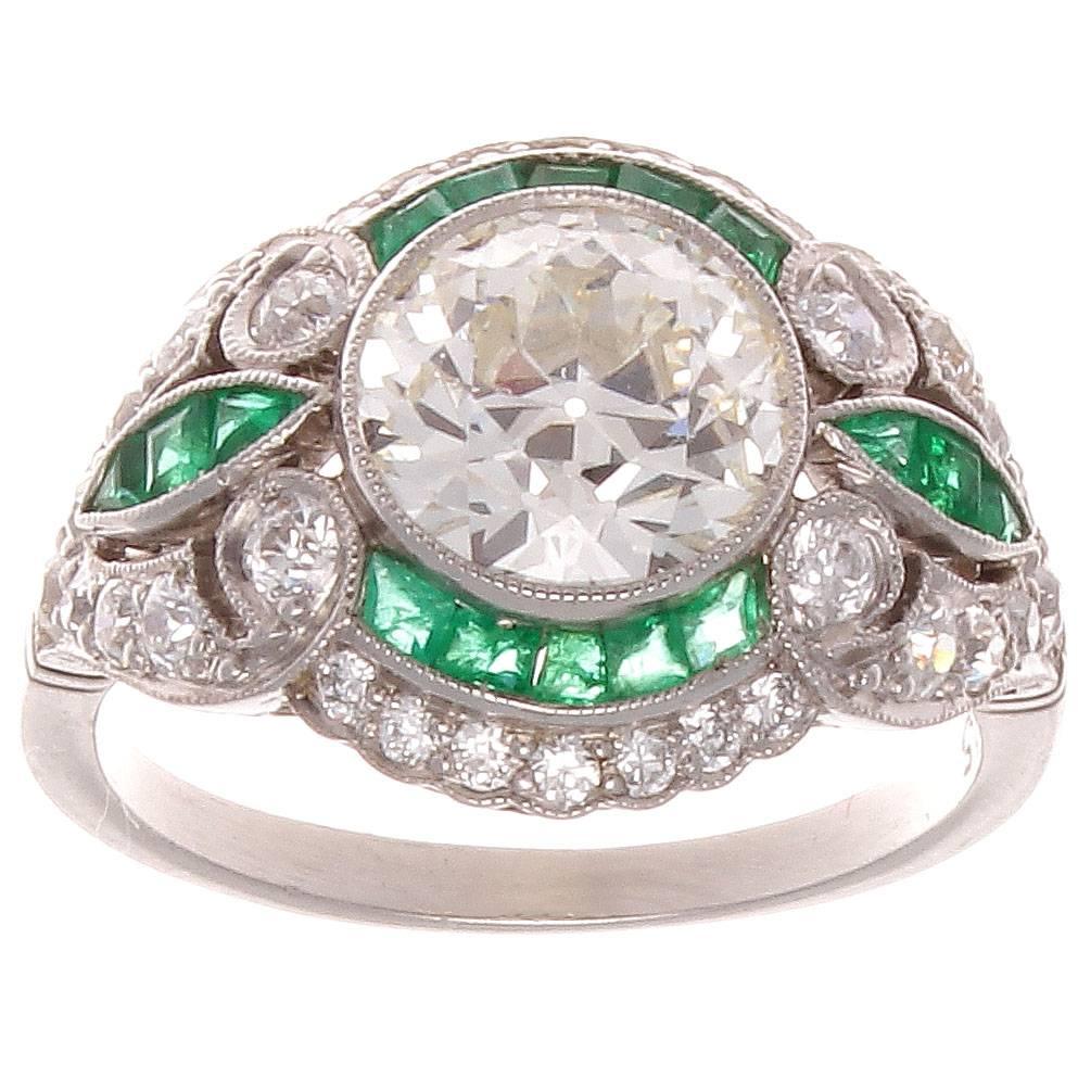A swirling symphony of color and form. The old European  cut 2.05 carat diamond is I color and VVS clarity. The accenting diamonds are near colorless and the forest green emeralds add color and vibrancy.

Ring size 6 1/2 and may easily be re-sized
