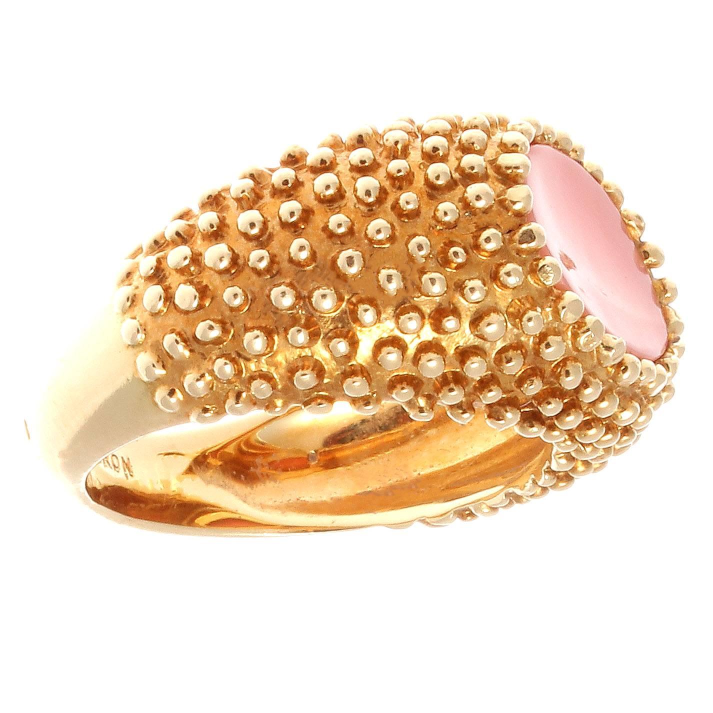 Crafted in 18k bead textured gold featuring a coral stone that is a perfect match for the golden hue of the ring. Signed Boucheron.

Ring size 5 and may be re-sized to fit.