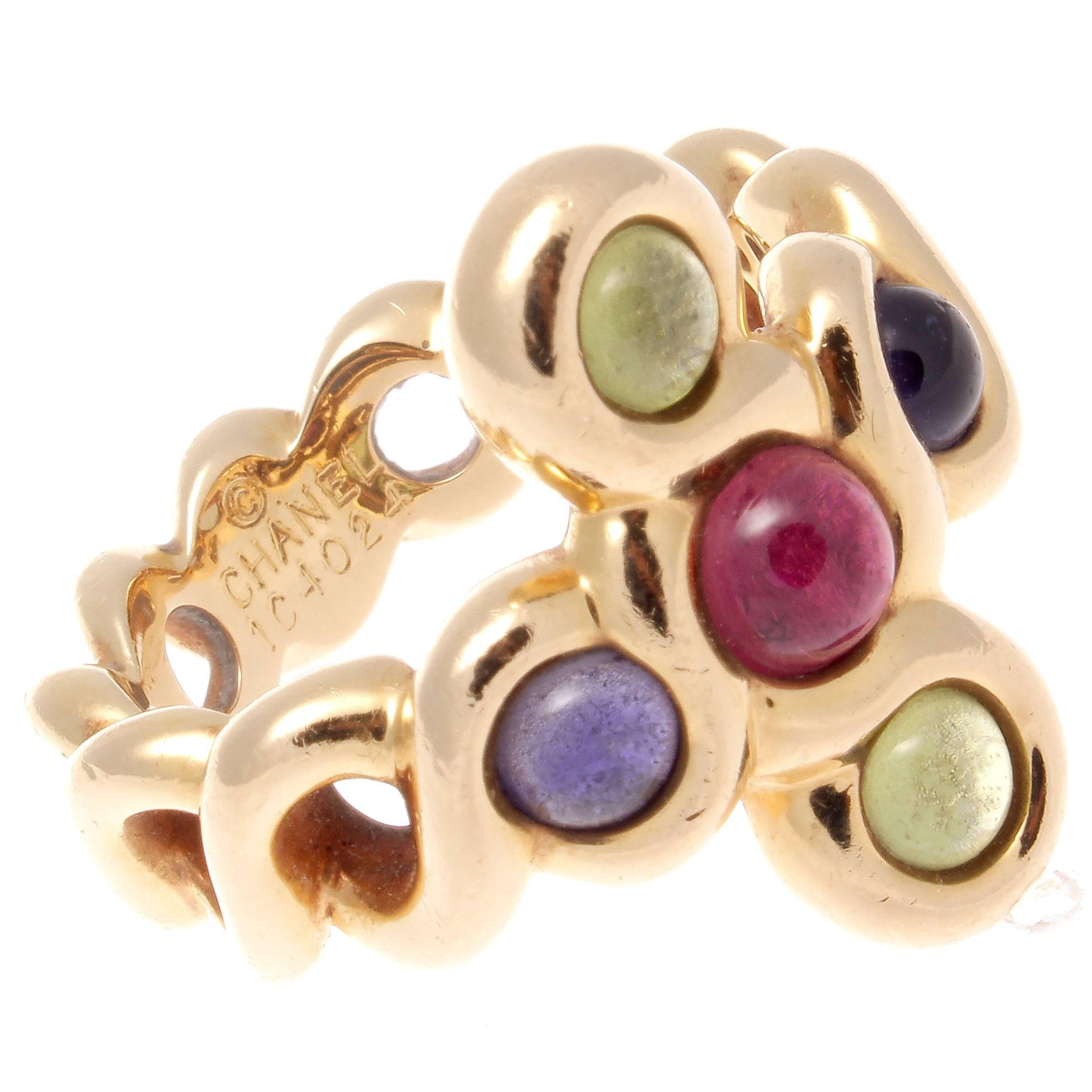 Created as a circular cross pattern the Chanel ring features cabochons of tourmalines and amethyst. Hand crafted in 18k gold signed Chanel with serial numbers. 