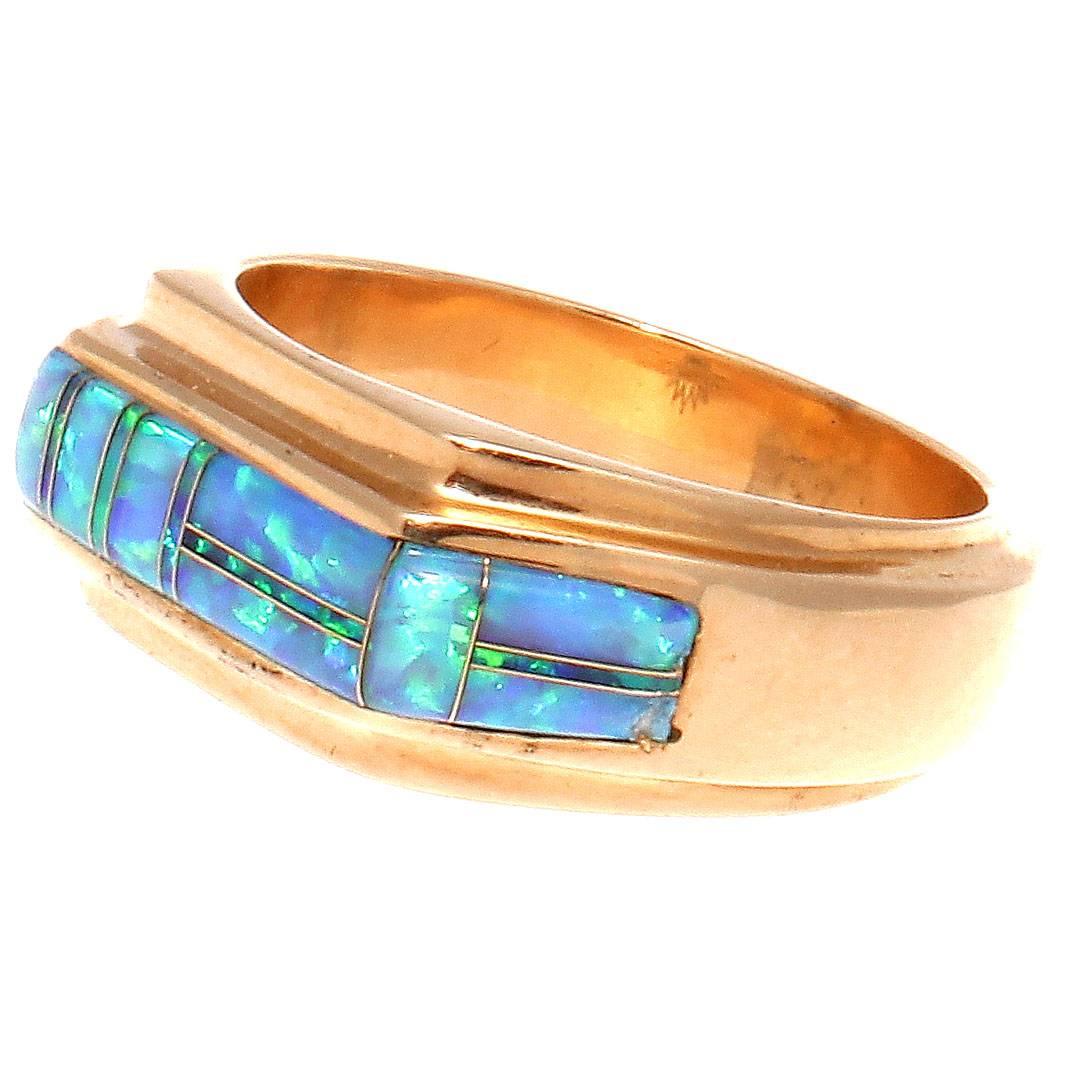 A rainbow of color illuminates this vintage ring. Featuring sections of multihued black opal that gently wrap around the contoured 14k gold ring.

Size 8-3/4 and may be resized to fit.