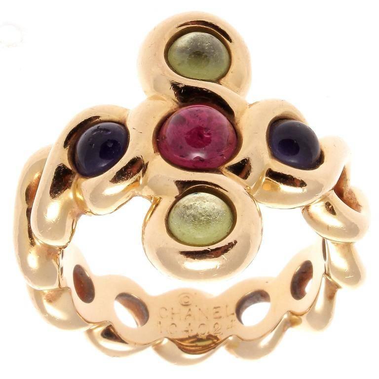 Created as a circular cross pattern the Chanel ring features cabochons of tourmalines and amethyst. Hand crafted in 18k gold signed Chanel with serial numbers.