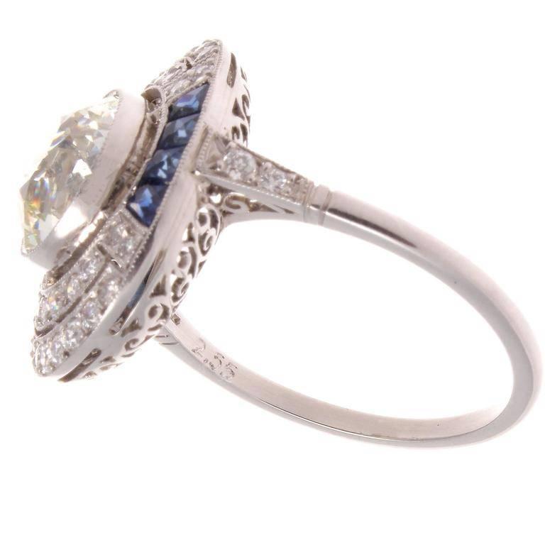The beautifully cut 2.55 carat old European diamond is J color and VVS clarity. With 36 near colorless old European cut diamonds and eight calibrated French cut pure blue sapphires. The expertly created platinum ring is hand made and the entire