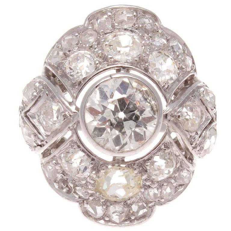 A well balanced geometric interpretation of the classic diamond cocktail ring. Featuring an old European cut diamond weighing approximately 0.90 carats that is G color, SI2 clarity with accenting diamonds weighing approximately 1.25 carats. The well