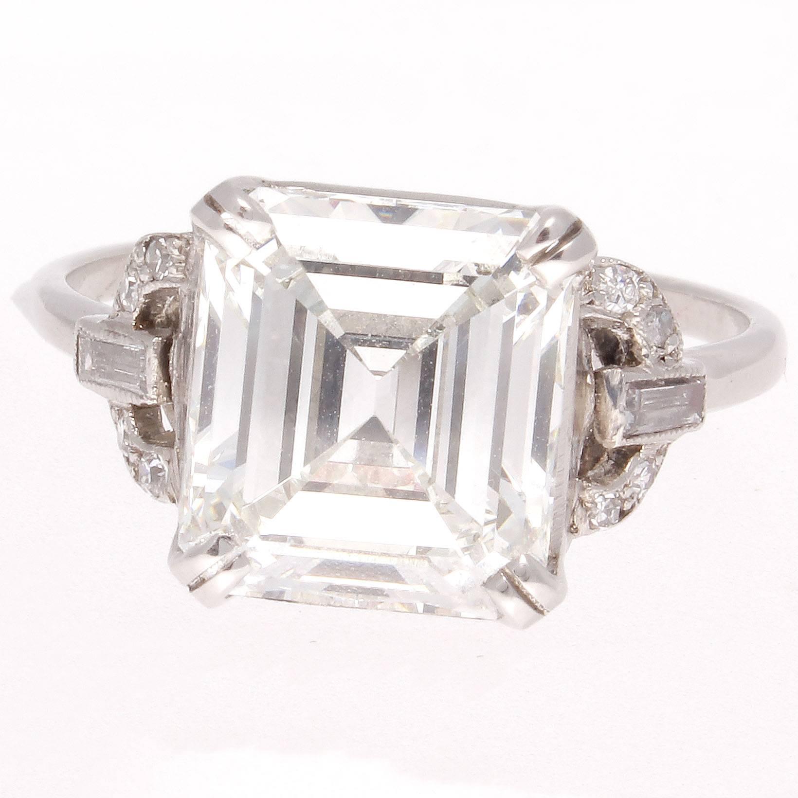 From the elegant Art Deco time period featuring a 4.12 carat emerald cut diamond that is GIA certified as H color and VVS2 clarity. The stone is classically proportioned and extremely bright.  Accented  by colorless diamonds and hand crafted in
