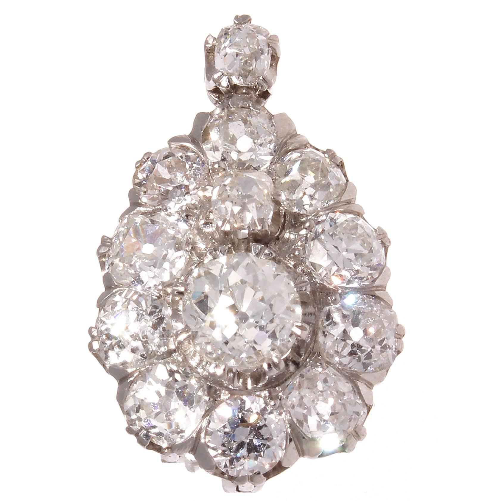 A cluster of light that will brighten any room and enhance any ear so lucky to be wearing it. Featuring two center diamonds weighing 1.36 carats. Surrounded by halos of perfectly matching old cut diamonds weighing approximately 4 carats. Crafted in