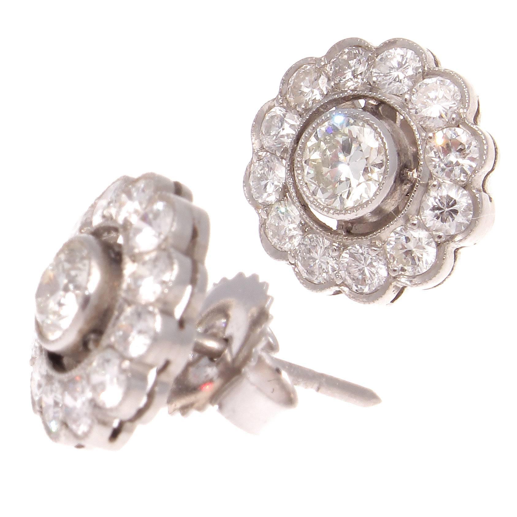 The classic diamond cluster earrings that always wears well and elegantly enhances the ear. Featuring 12 round white, diamonds surrounded the center round white diamond. Sparkle and scintillation in each. Crafted in platinum. 