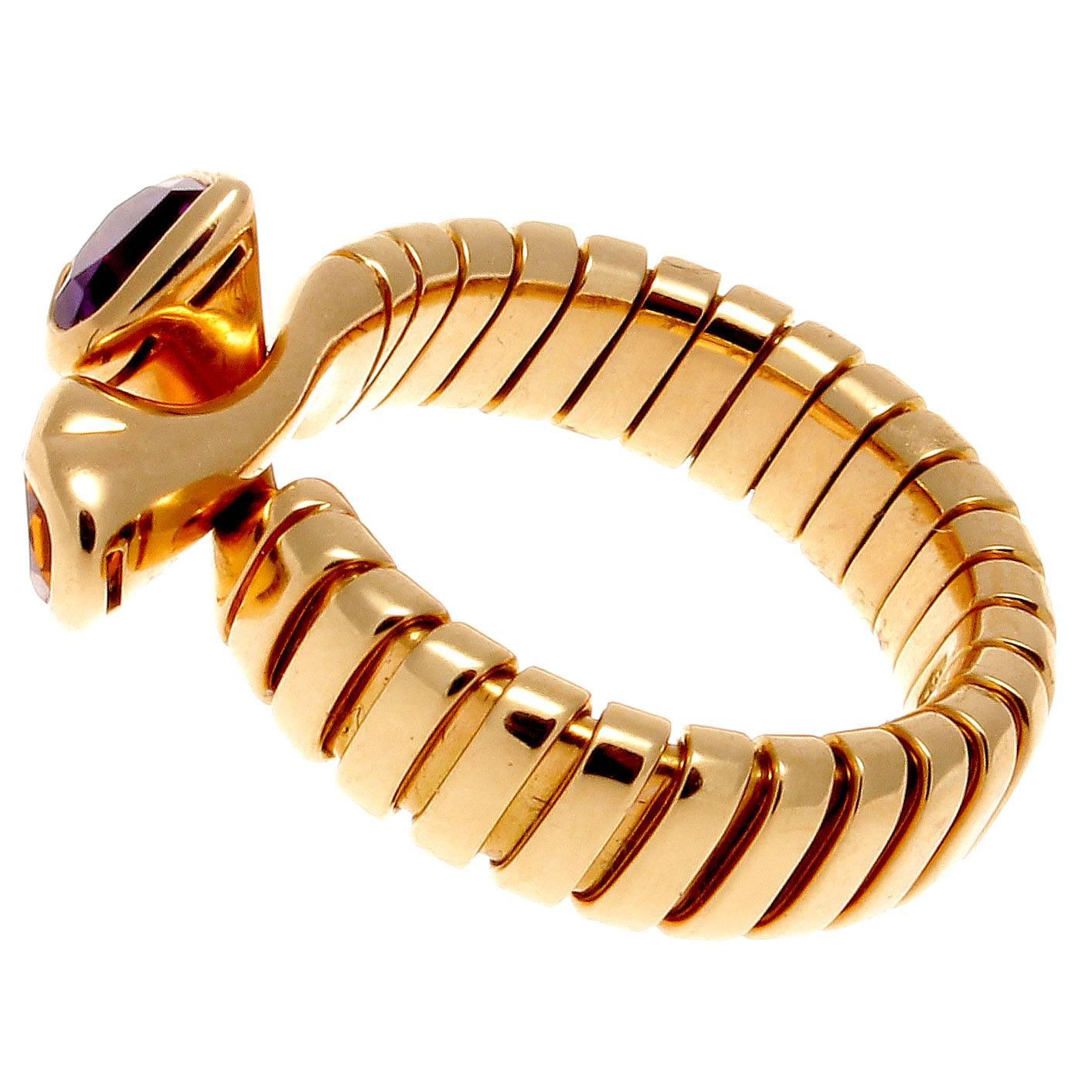 Stylish and colorful from Bulgari. Designed with interlocking hearts of purple amethyst and golden citrine set amid ribbed sections of 18k gold. Signed Bvlgari. 

Ring size 6 with flexibility to fit bigger sizes.