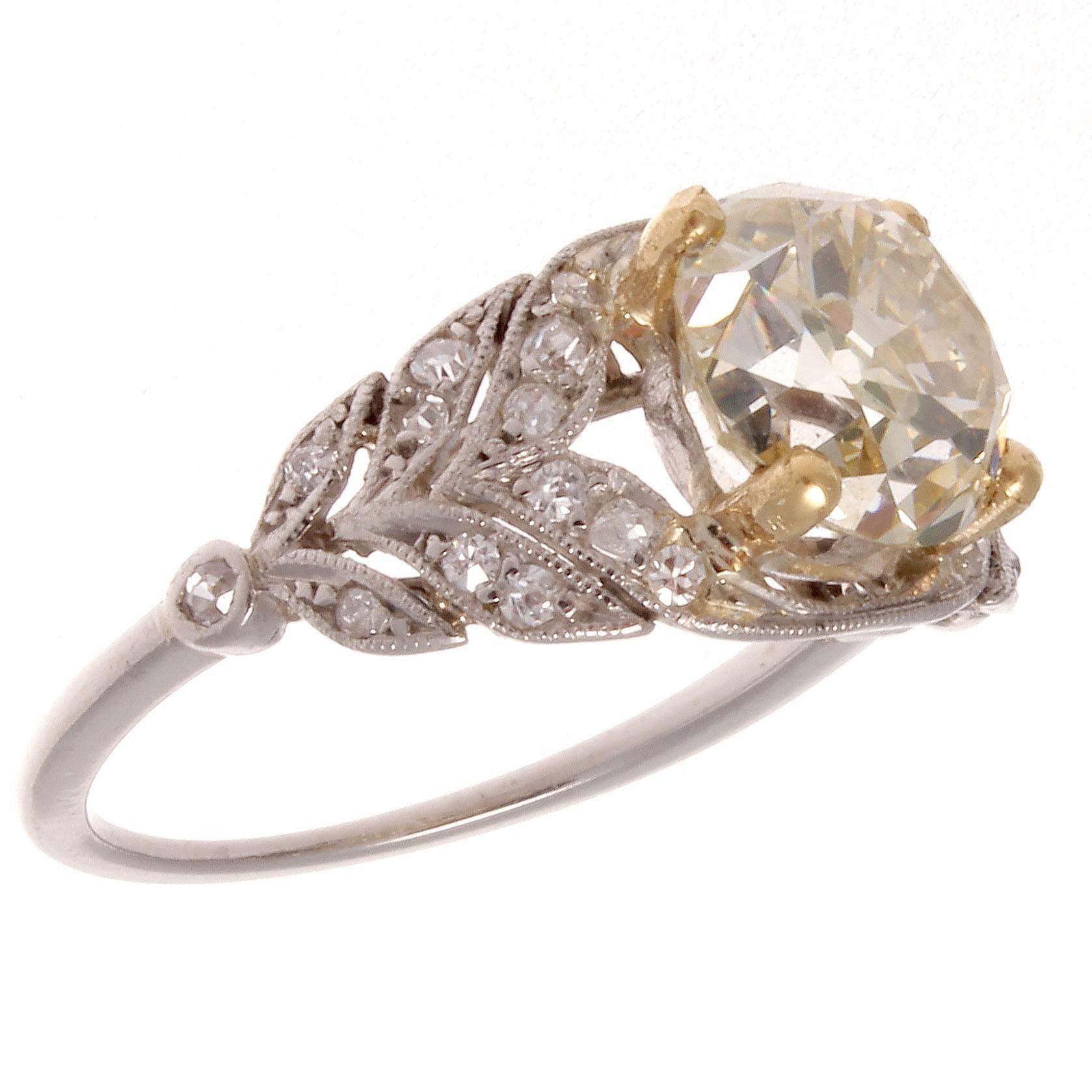 A sensual art deco creation with an emphasis on intricate design which defined the 1930's. Featuring a 2.59 carat old European cut diamond that exudes a fancy yellow color with well placed numerous near colorless diamonds. Hand crafted in platinum