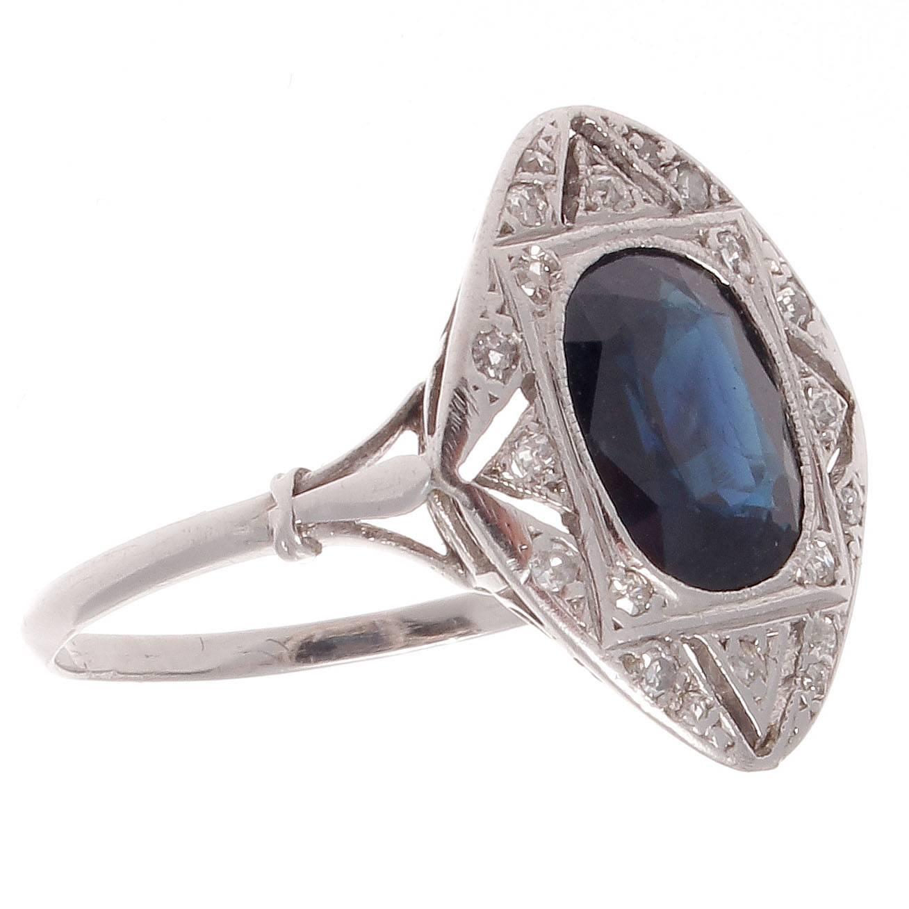 Geometric form from an era of planned abstract brilliance. Featuring a deep blue oval cut sapphire that is surrounded by numerous diamonds and perfectly engraved platinum.

Ring size 6 and may be re-sized to fit.