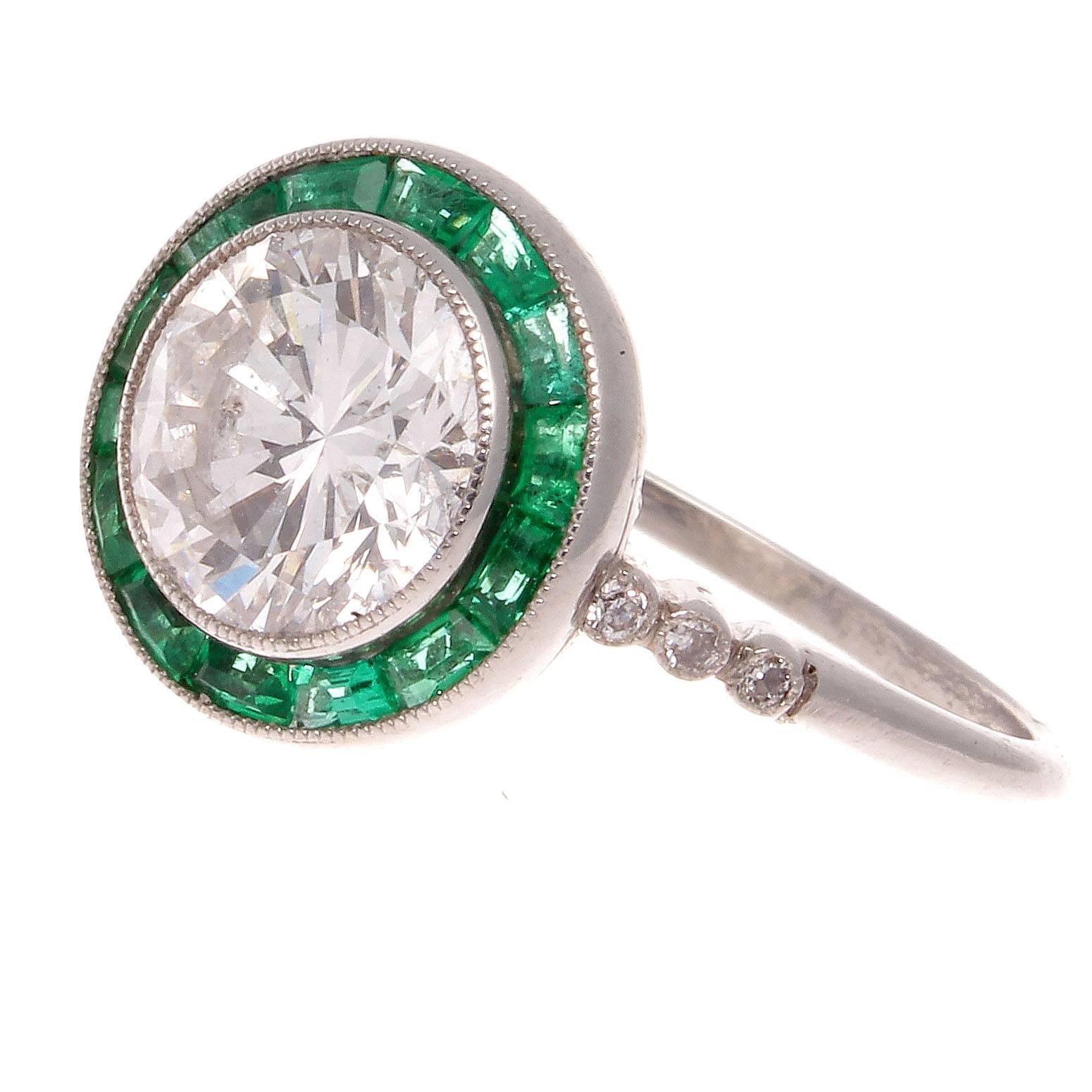A timeless design that first appeared in the latter part of the 19th century. Featuring a 1.88 carat round brilliant cut diamond that is J,K color, VS1 clarity. Surrounded by a vibrant halo of forest green emeralds. Hand crafted in platinum.
Ring