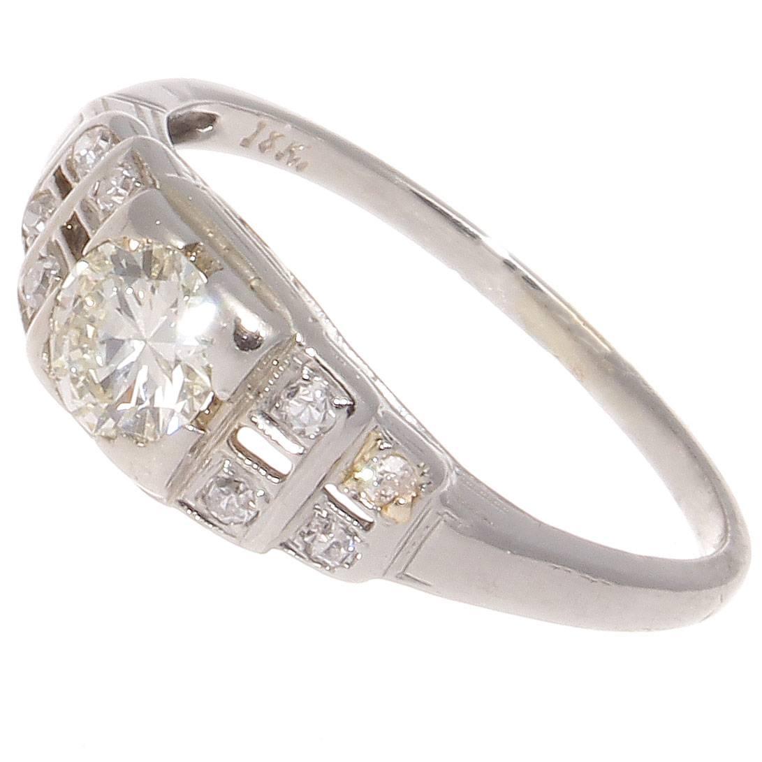 An architectural masterpiece of art deco brilliance created this classical representation of the engagement ring. Featuring an approximately 0.30 carat old European cut diamond surrounded by descending levels of strategically placed matching