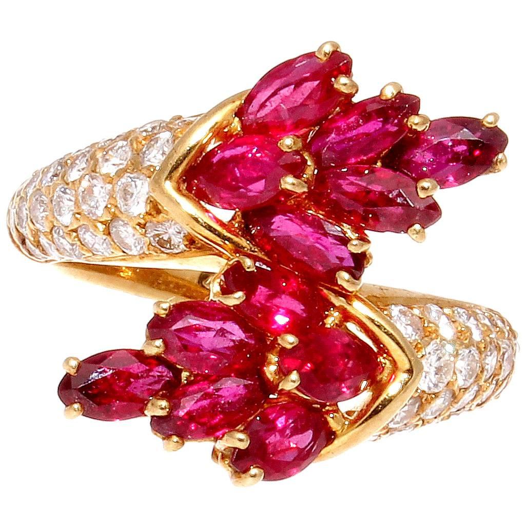 Modernistic design is what defines Piaget and their artistically creative jewelry. Realized in a crossover creation of numerous vibrant red marquise cut rubies that flow into cascading white diamonds down the glistening 18k gold ring. Signed