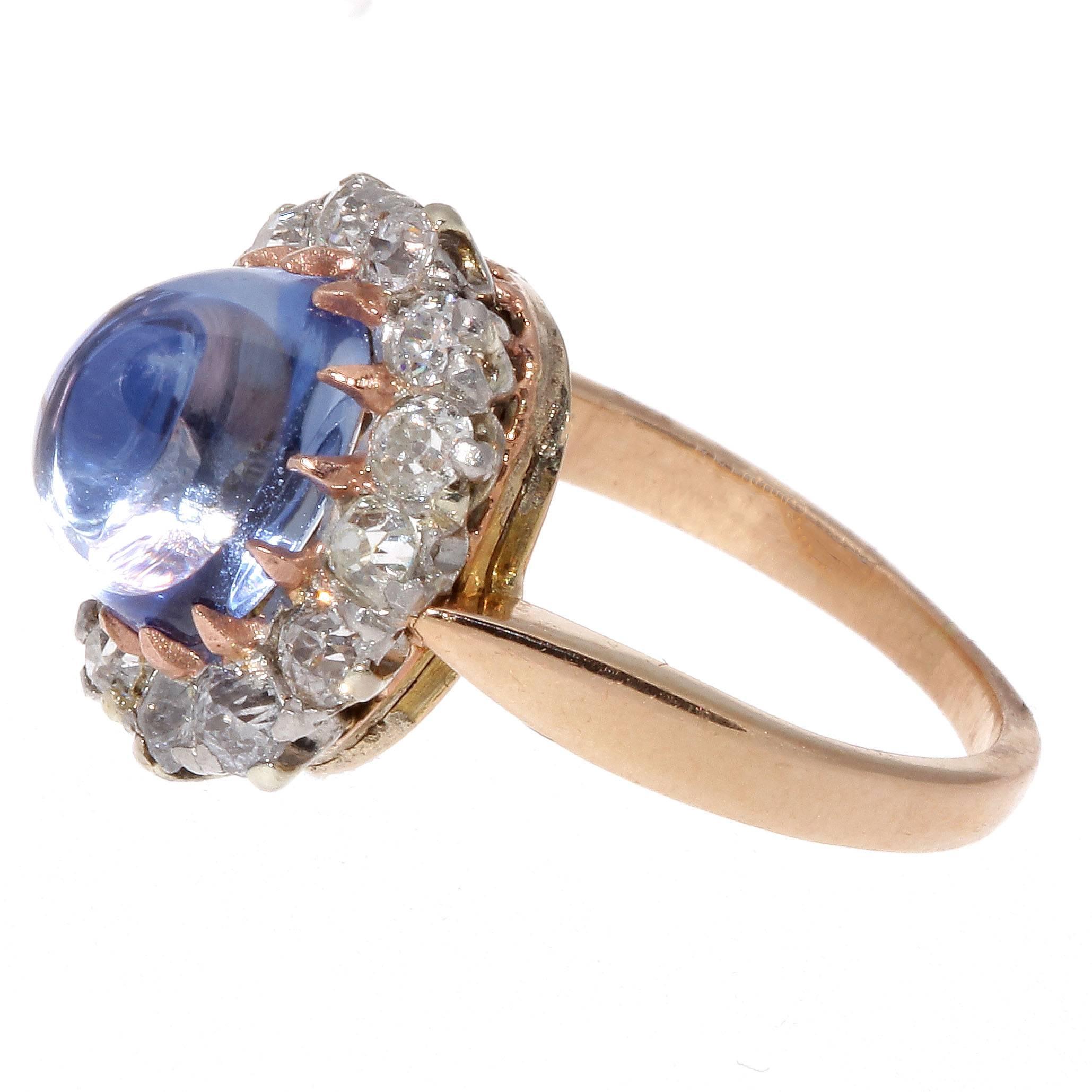 This unusual cut cabochon sapphire makes the ring not only rare but unique in style. Featuring a sparkling and finely finished cornflower blue sapphire that is surrounded by a halo of old cut diamonds. Hand crafted in 18k gold.