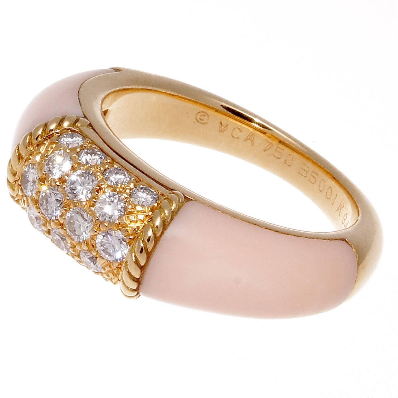 The classic Philippine ring from Van Cleef & Arpels. Designed with pave set diamonds in textured 18k yellow gold accented by glowing angel skin coral cascading down either side. Signed VCA, numbered and stamped with French hallmarks.