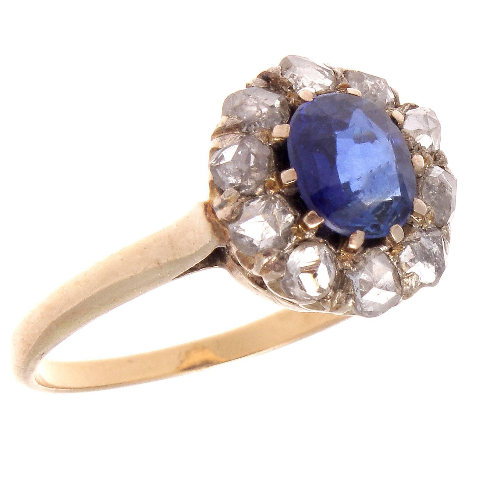 A Victorian cluster ring featuring a vibrant royal blue sapphire that is surrounded in petals of antique rose cut diamonds. This ring displays the always pleasing flower motifs that were so popular at the turn of the 19th century. Hand crafted in