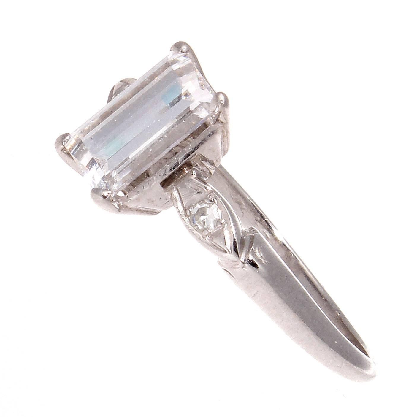 Love is expressed in many ways but tradition has made this the ultimate sentiment to say forever. Classically designed with a 1.07 carat emerald cut diamond that is GIA certified as E color, SI2 clarity. Simply accented on either side by a single