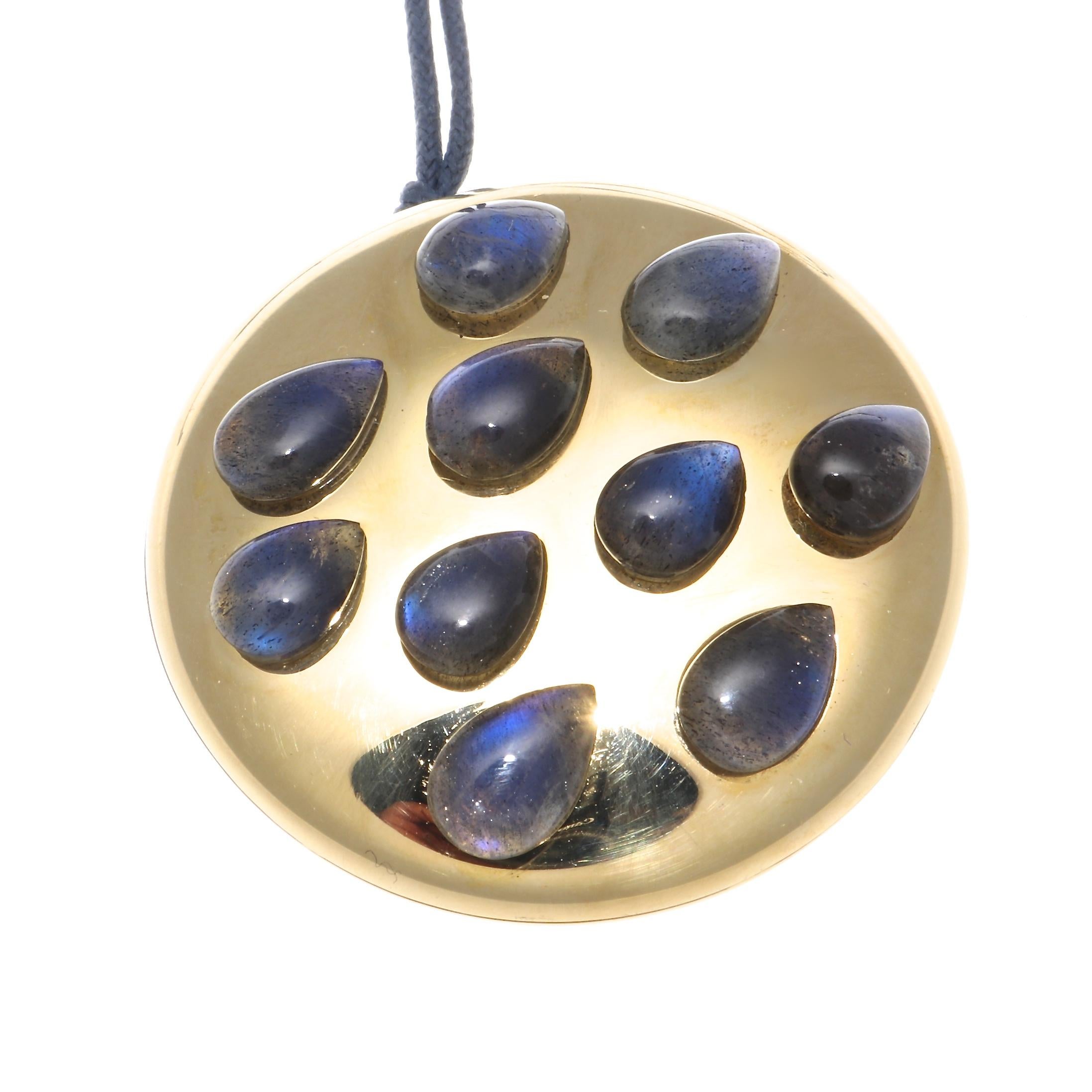 Unique in every sense. Pomellato is synonymous with creativity and color and focuses on a powerful, fashion-forward identity. Featuring raindrops of royal blue labradorite beaded on a glistening 18k golden token. Adorned from a blue silk necklace.