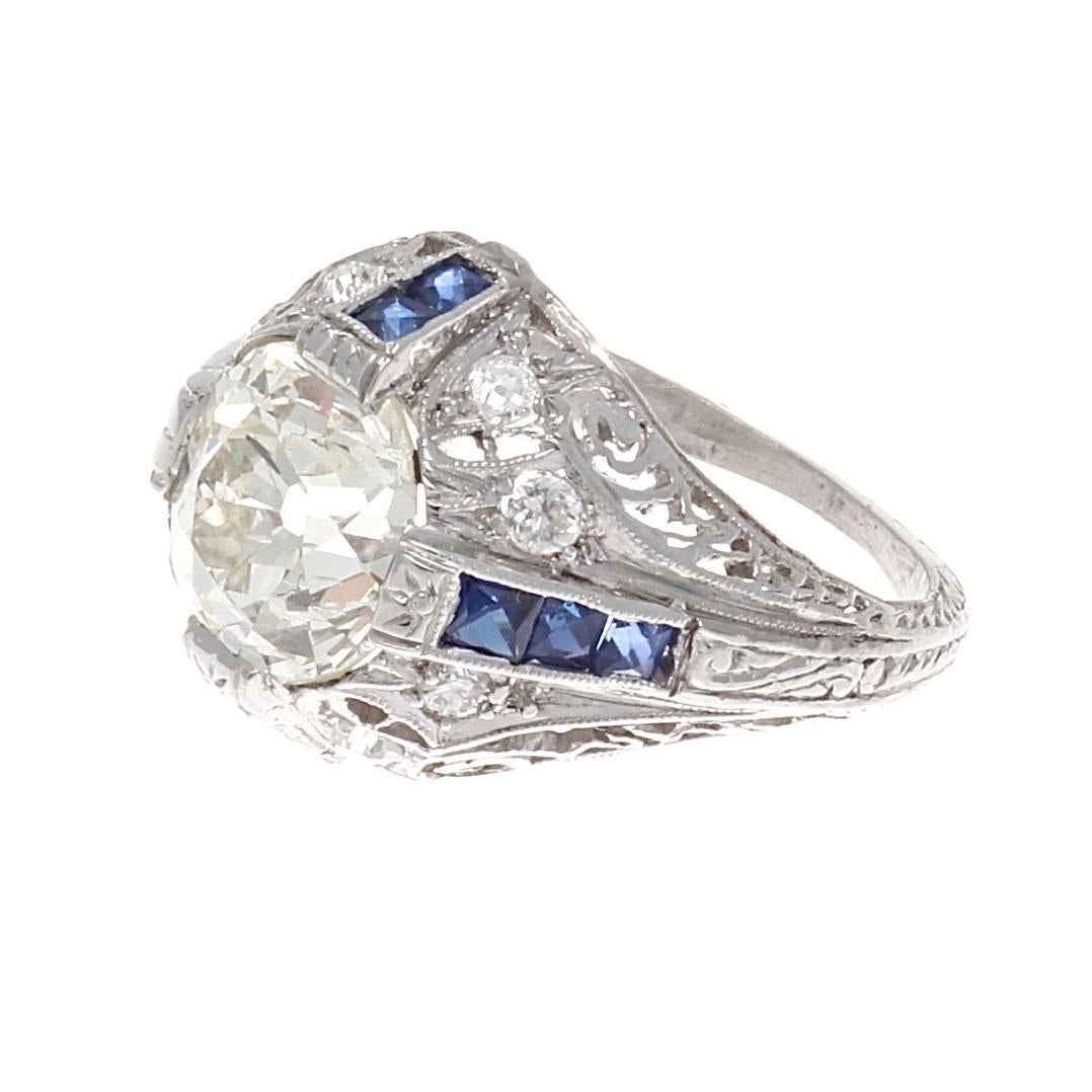 The early 1920's was an elaborate lust for extravagance. Featuring a glowing 2.34 carat old European cut diamond that is set in a basket of weaved platinum decorated with navy blue sapphires and near colorless old cut diamonds. Hand crafted in