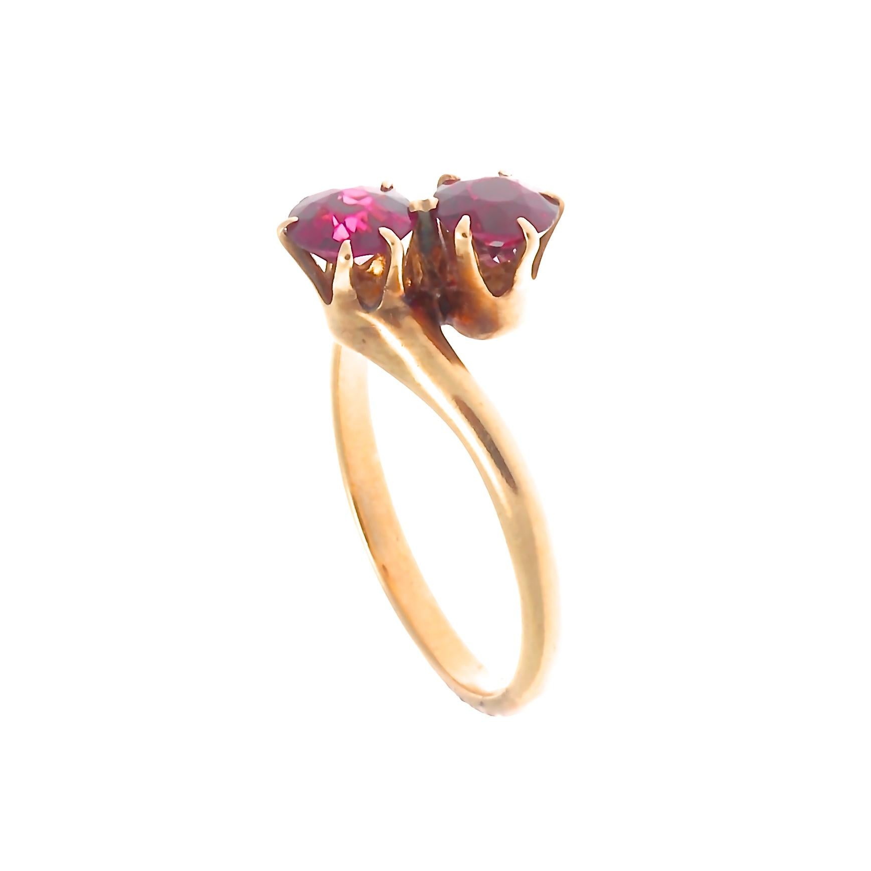 Elegance through simplicity. Featuring two glowing garnets embracing through swooping design. Crafted in 14k gold. Ring size 8-1/4 and can easily be resized to fit, if needed this would come complimentary with your purchase.