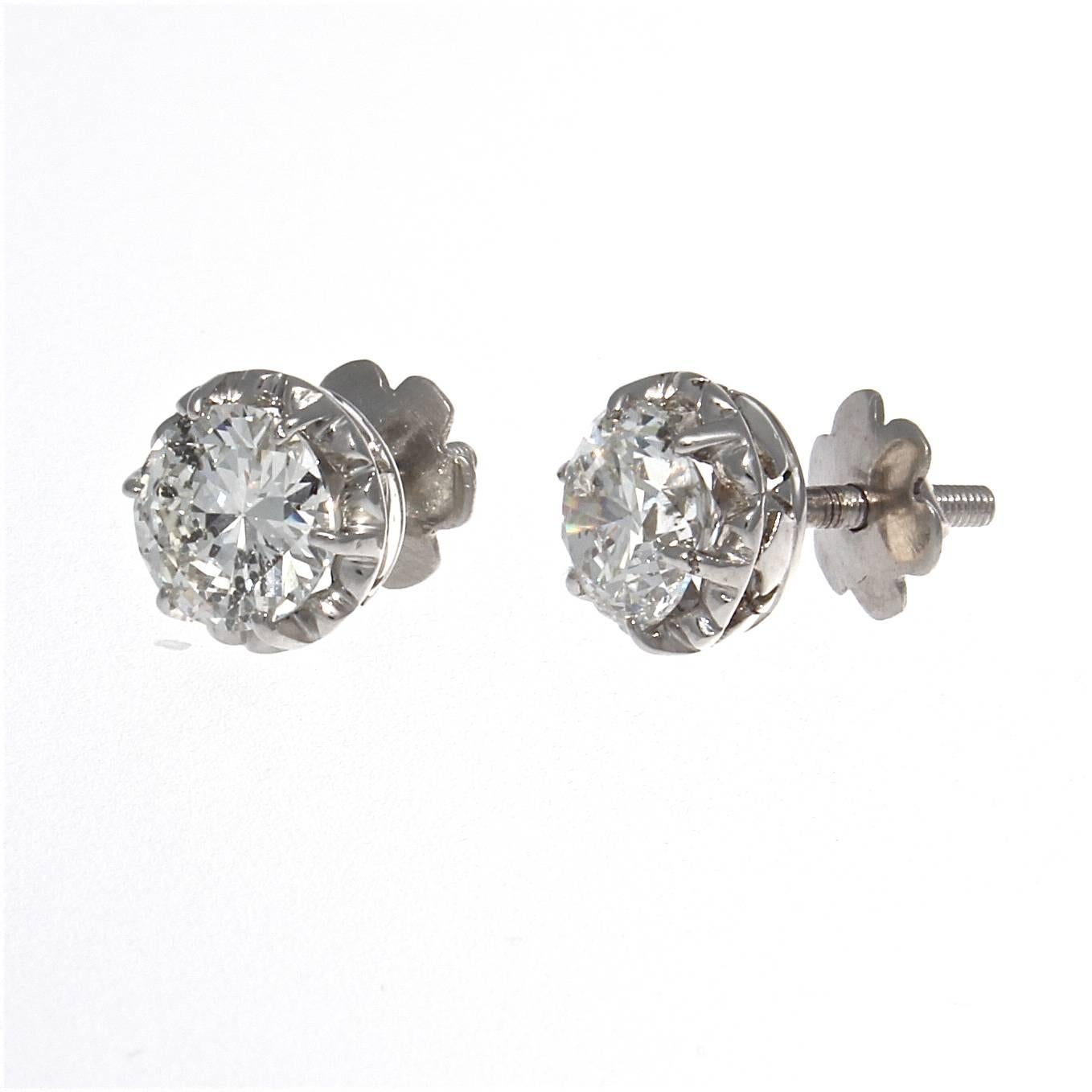 A beautiful pair of diamond stud earrings. Created with two round brilliant cut diamonds that weigh 2.12 carats total and are F-G in color, SI2 in clarity. The designer has creatively added an outer circle of platinum nicely complimenting the