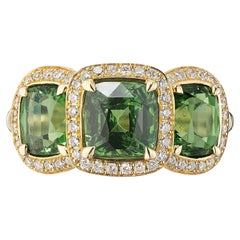 Anello con tripla tsavorite e alone di diamanti in oro 18 carati