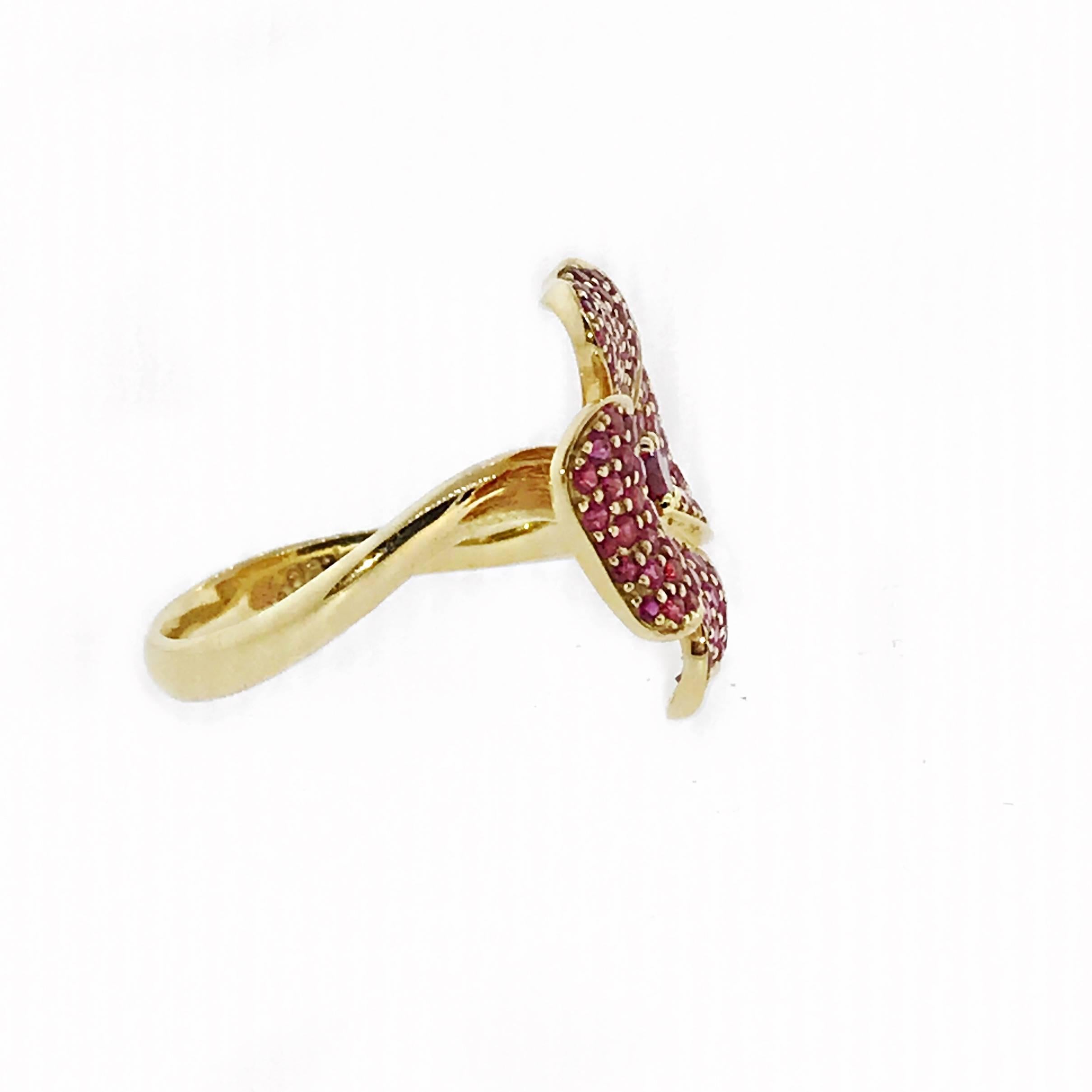 Ruby and pink sapphire flower ring in 18k yellow gold. Ruby is the July birthstone. Perfect as an anniversary gift, push present or birthday present. 

The flower ring has a ruby center stone with pink sapphires emanating from the center with in a