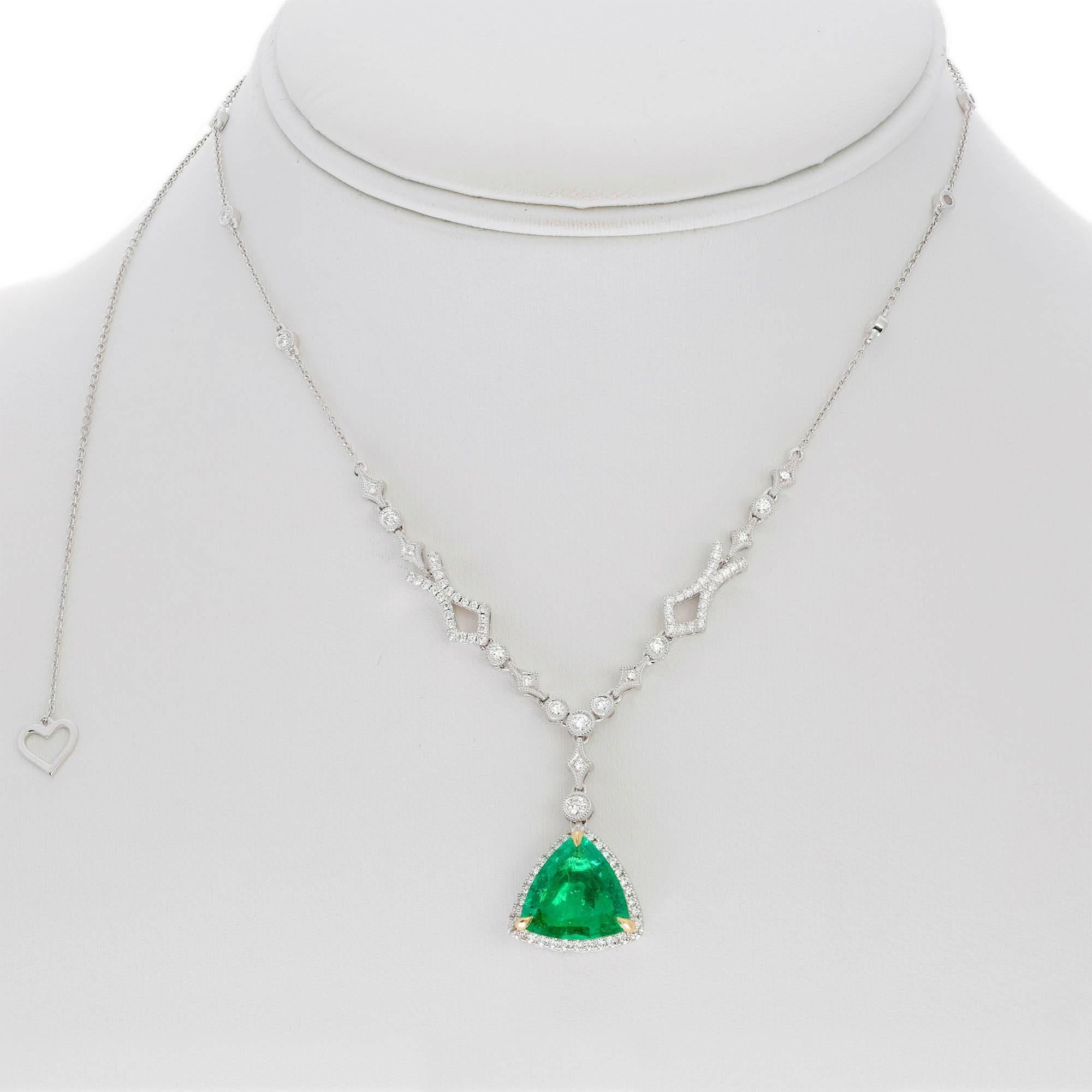 Trillion Cut Emerald hanging pendant in bezel set diamonds with milgrain edges.  Pendant in is set in 18k white gold. 

Emerald is one of the most powerful gemstones in history. Emerald is said to be ruled by the the planet Mercury, which is the