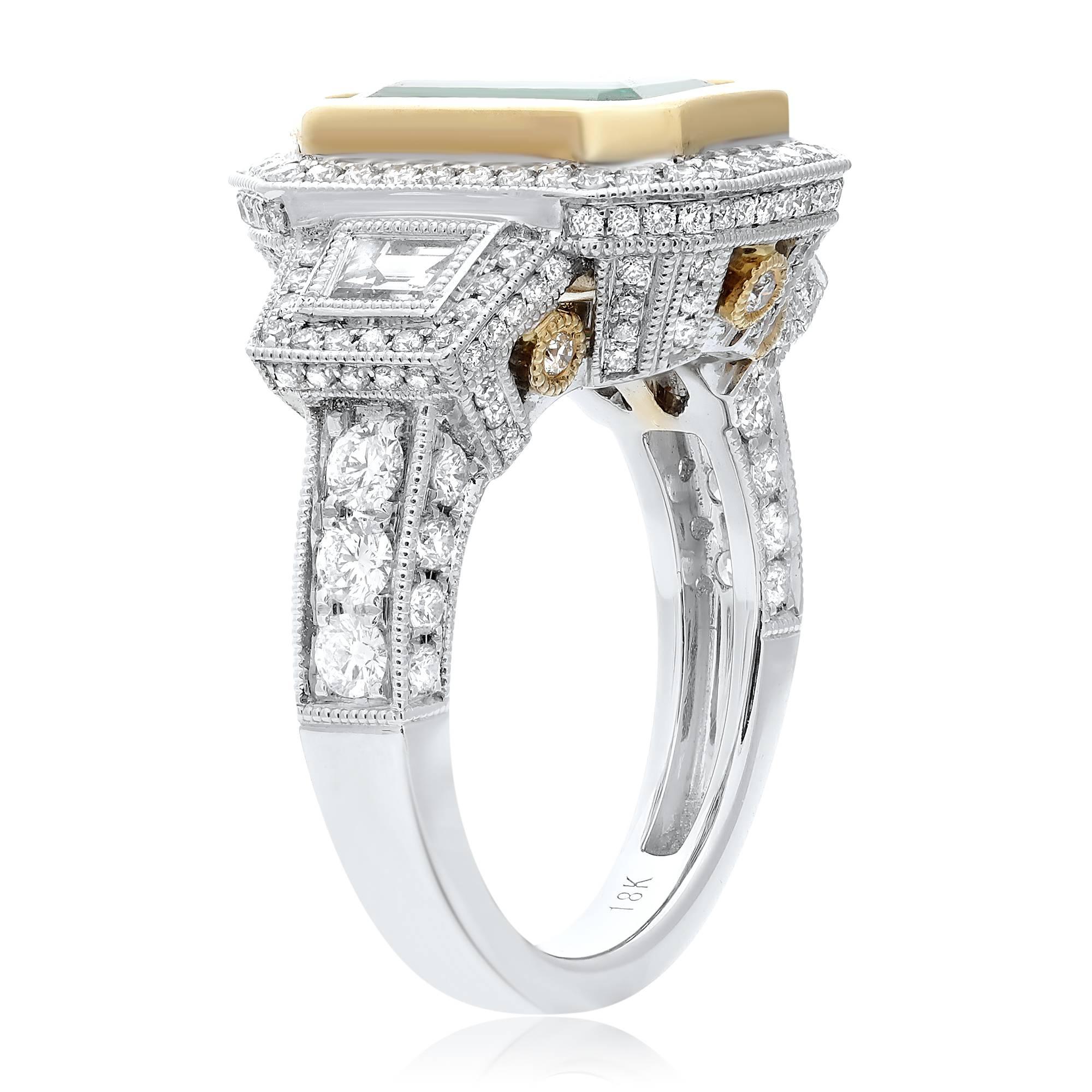 3.84 carat EGL certified Emerald Cut Emerald bezel set in 18k yellow gold. Beautiful deep green emerald is flanked by two perfectly matched diamond trapezoids. Diamond pave around the three main stones and around the basket. Style is enhanced by