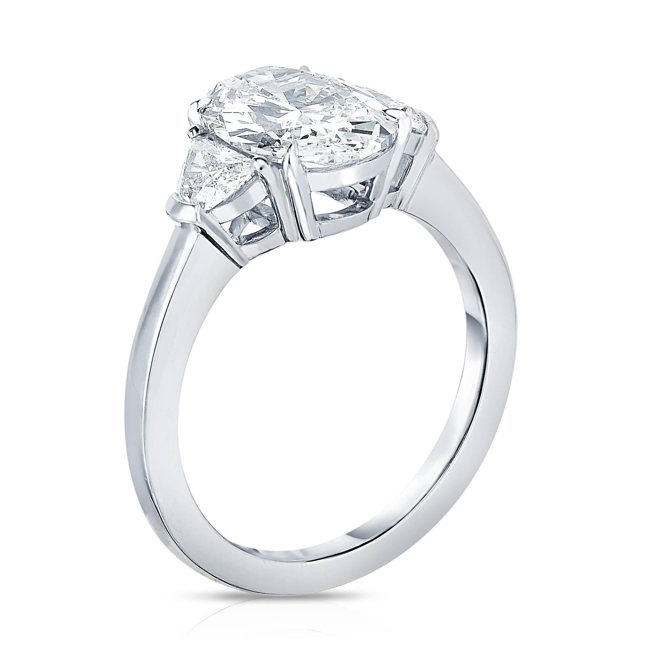 Marisa Perry Three Stone Engagement Ring in Platinum featuring a 2.10 carat Oval Diamond with G color and Internally Flawless - IF clarity. Featuring two G color VS1 clarity half moon side stones totaling 0.35 carats.  

This elegant engagement ring