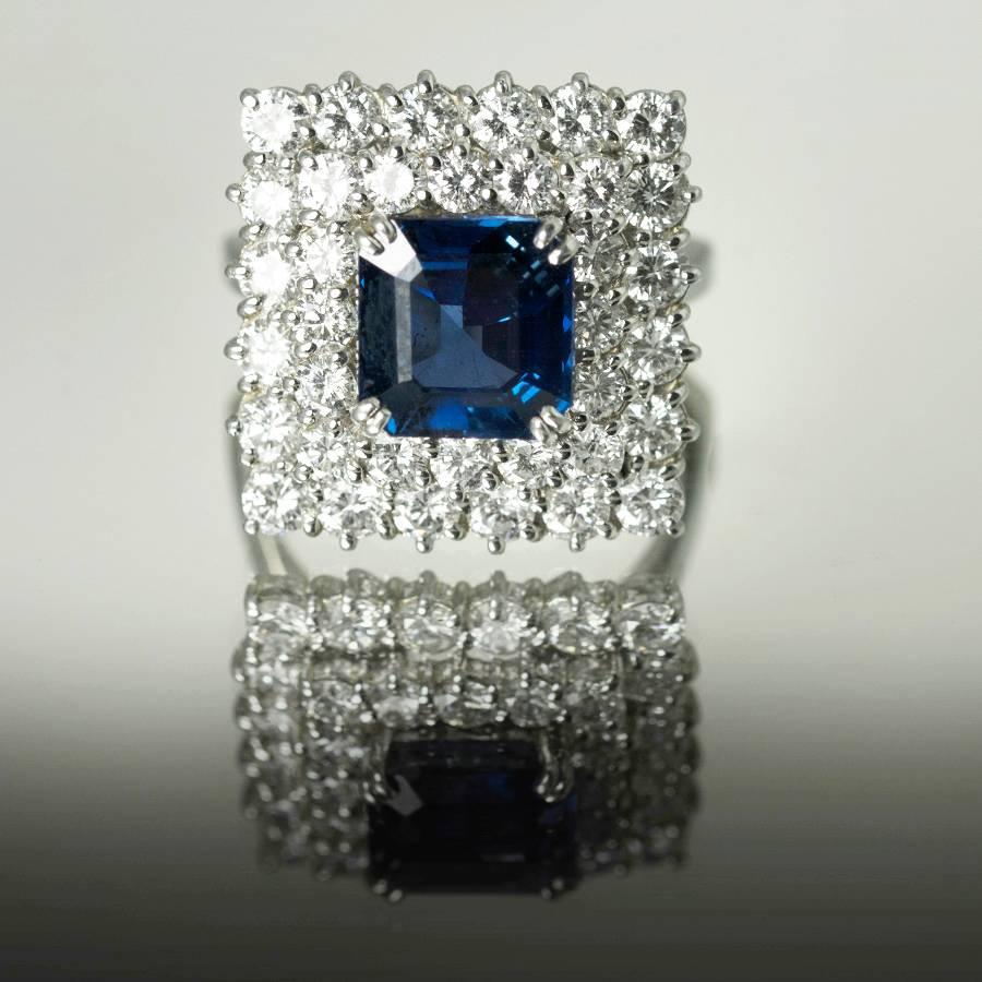Hand Fabricated Platinum Ring by Keith Davis for Thayer Jewelers. Containing one square emerald cut natural sapphire weighing 4.92 carats and 36 collection color clarity round brilliant diamonds weighing 2.82 carats. 

Keith Davis 
Before coming