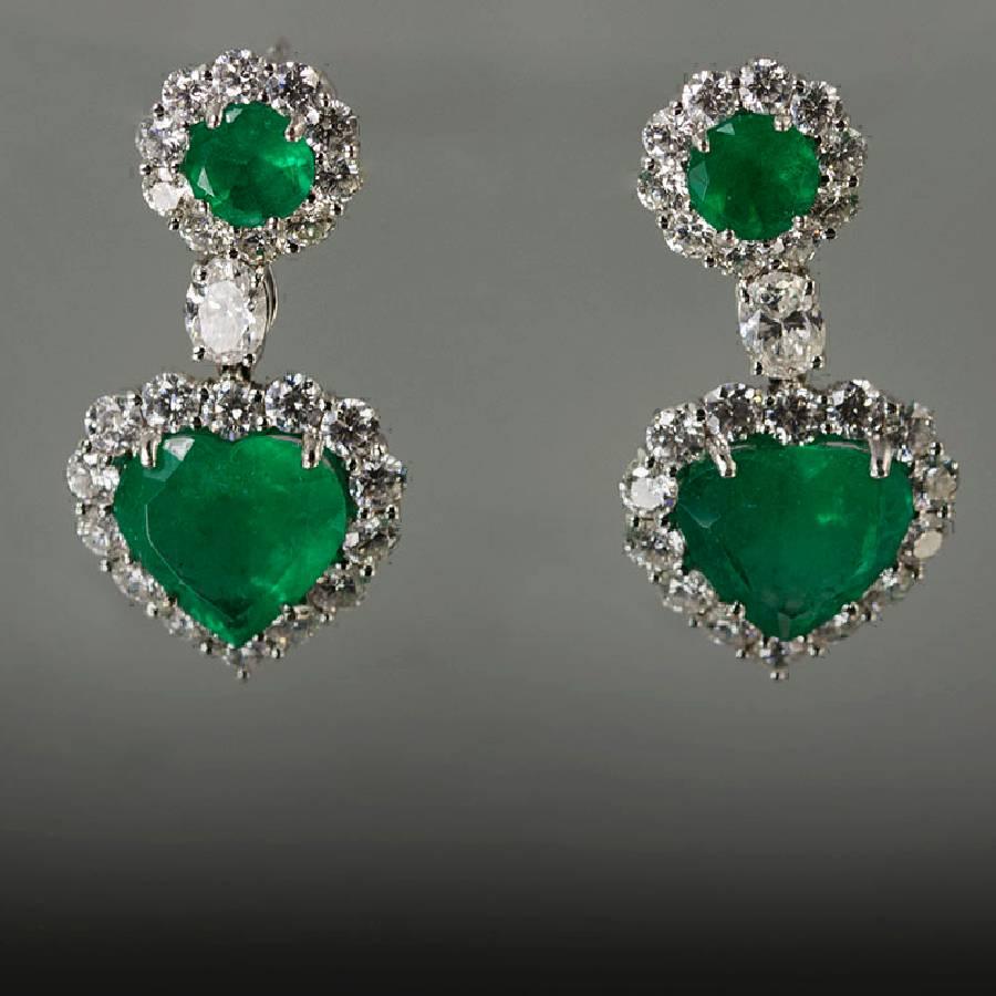 18k earrings with 2 heart shape and 2 round emeralds emeralds weighing 7.12 carats and 2 oval diamonds weighing 0.60 carats and 48 round brilliant diamonds weighing 3.13 carats.