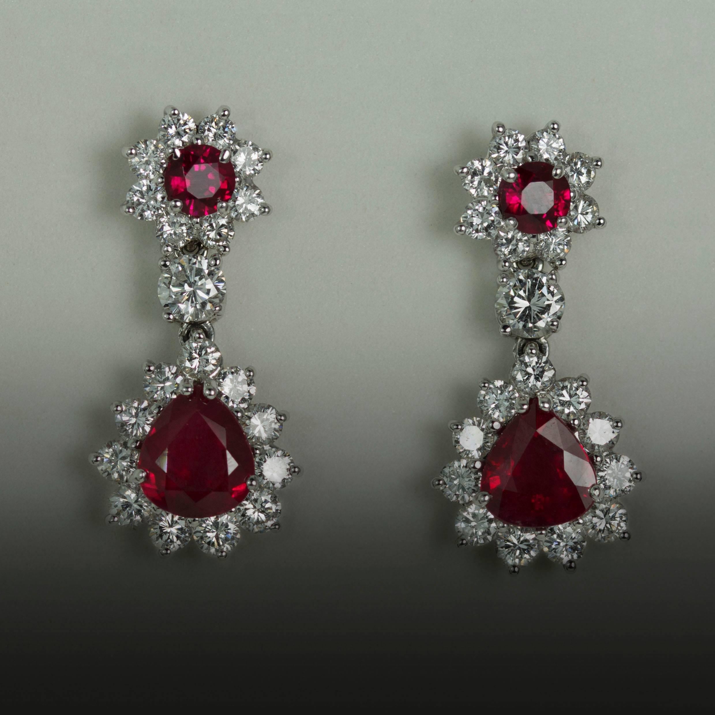 18K Earrings containing 2 natural pear shape rubies weighing 2.93 carats, 2 round rubies weighing 0.55 carats and 40 round brilliant diamonds weighing 2.36 carats.
 